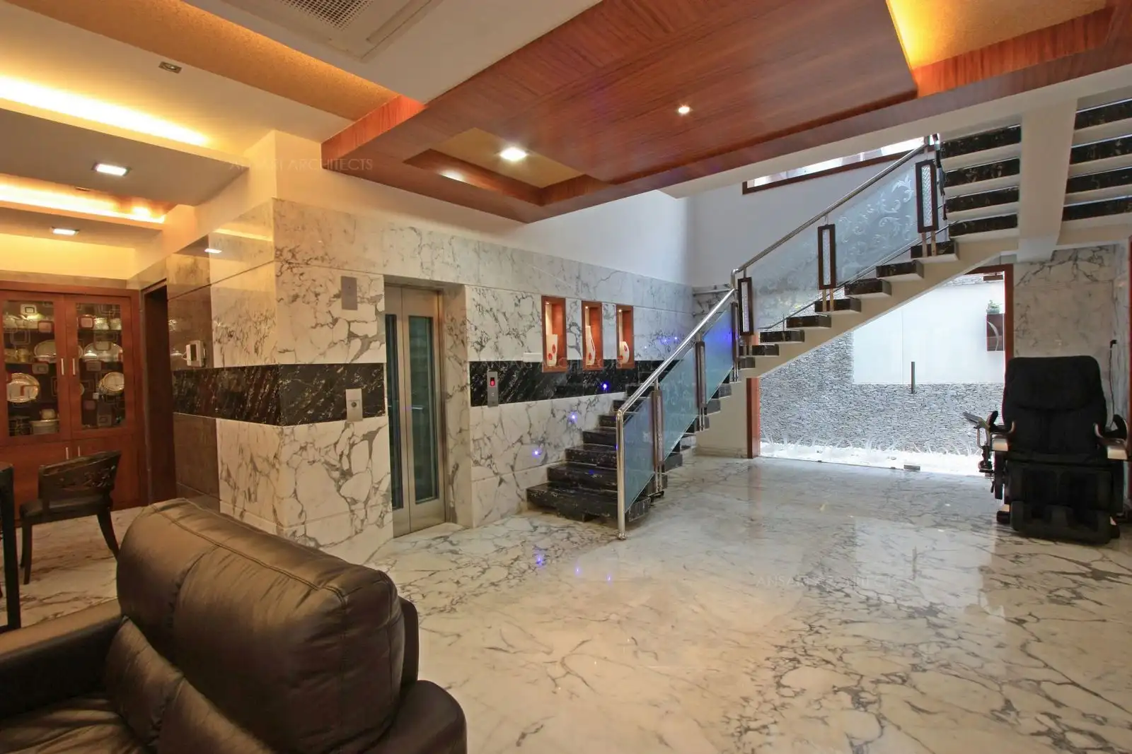 Light colour stauario marble continues as wall cladding to make the space look wider.Contrast black marble in between breaks the monotony.