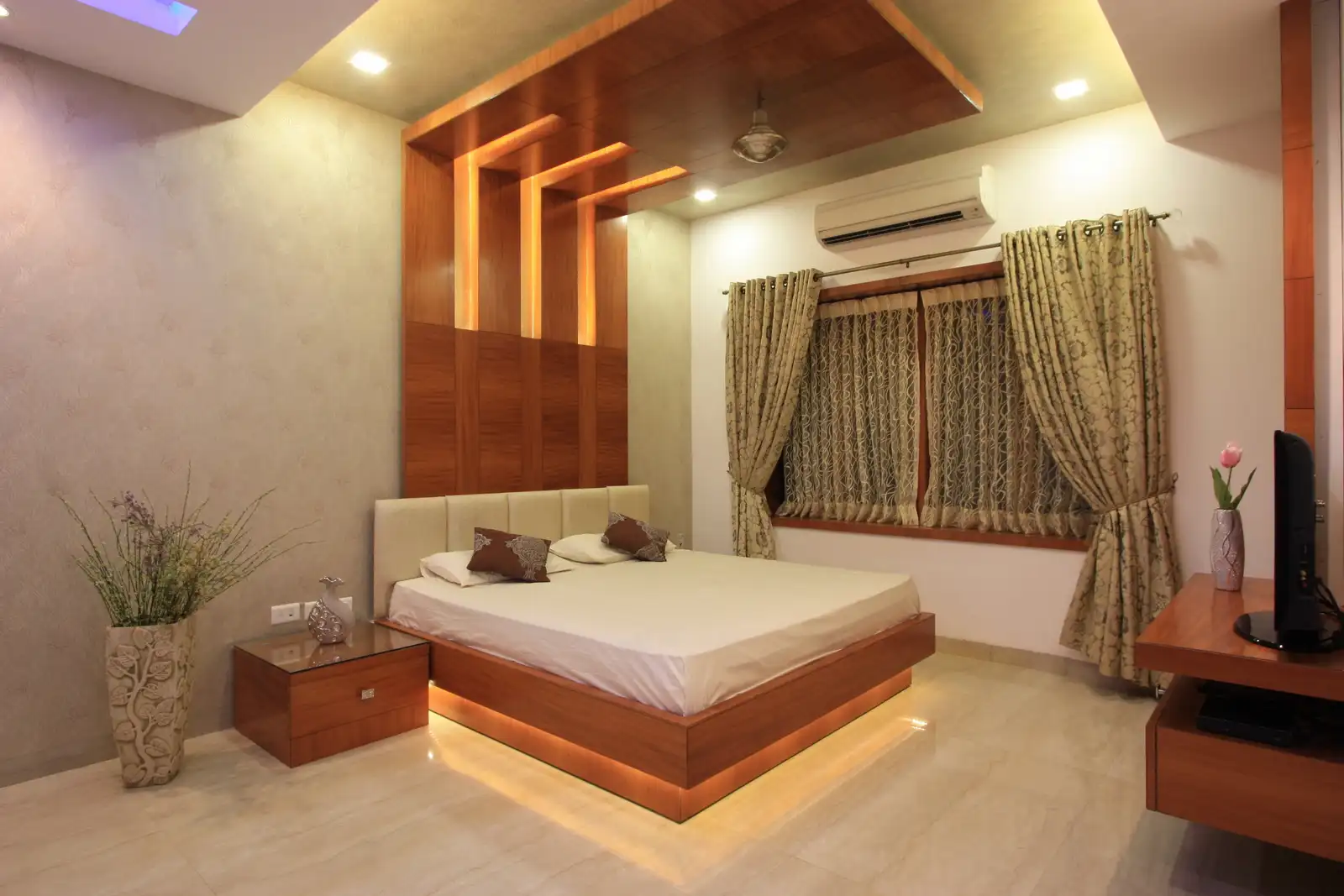 Bedroom-1 has high wooden panelling against simple wall paper behind the bed which turns to the ceiling for a dramatic look.