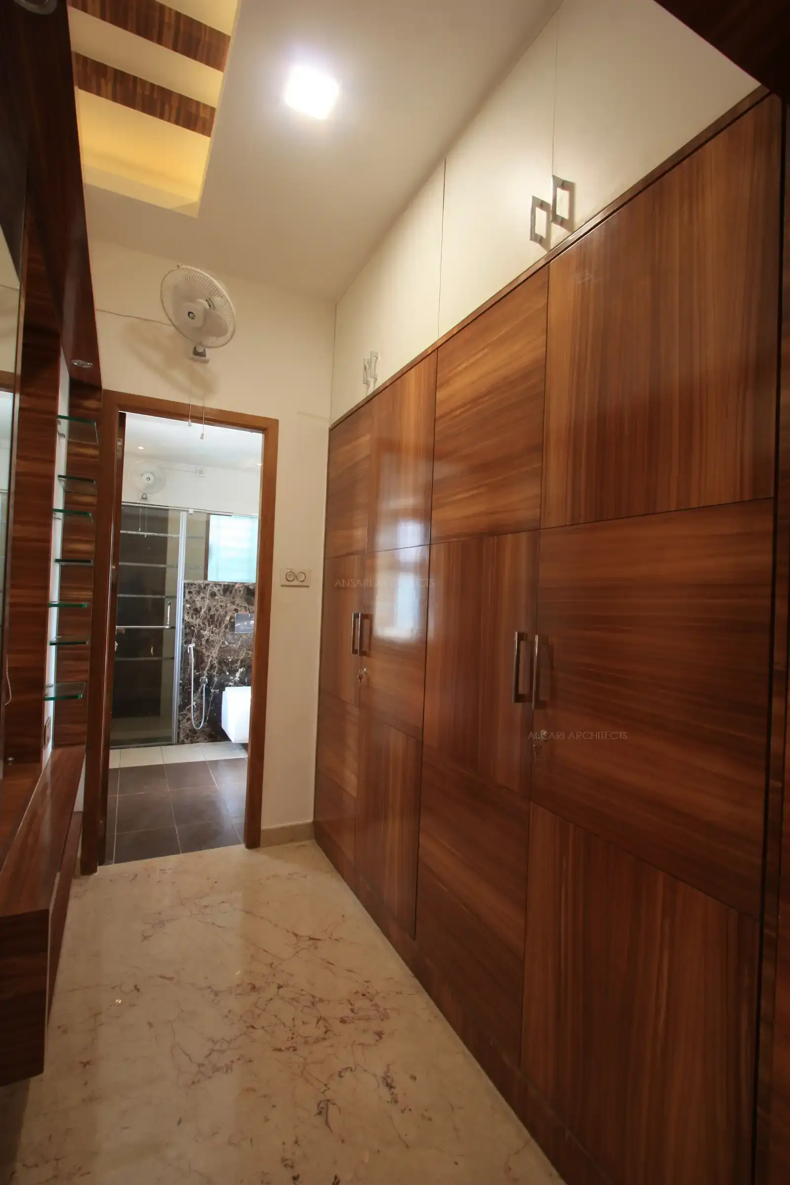 The dressing area in the master bedroom has huge wardrobe with richly selected veneers and design created with natural grains of the wood.
