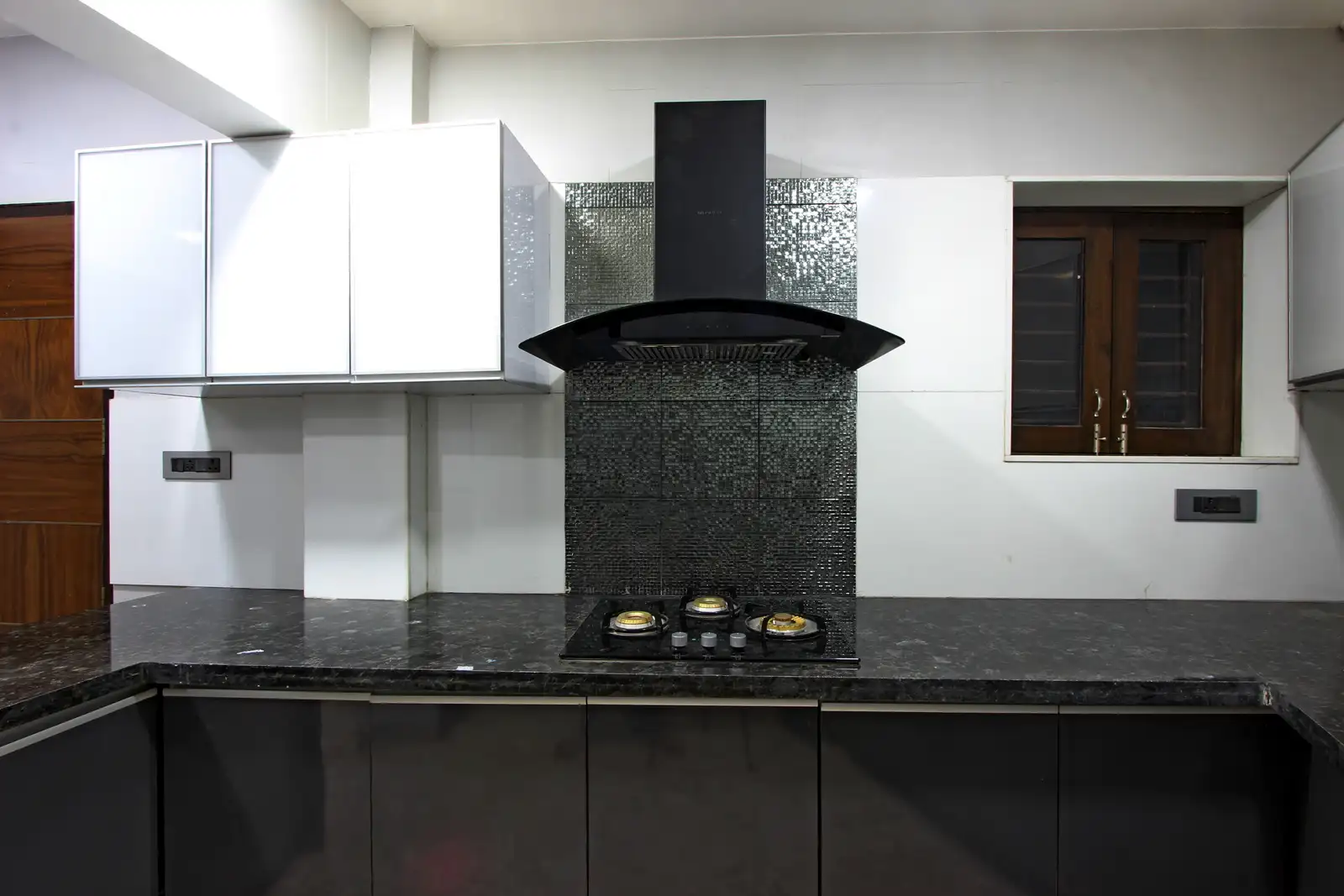 Handle free cabinets give a neat and streamlined look to this space. Uncluttered look , to camouflage the hood and the behind tile.