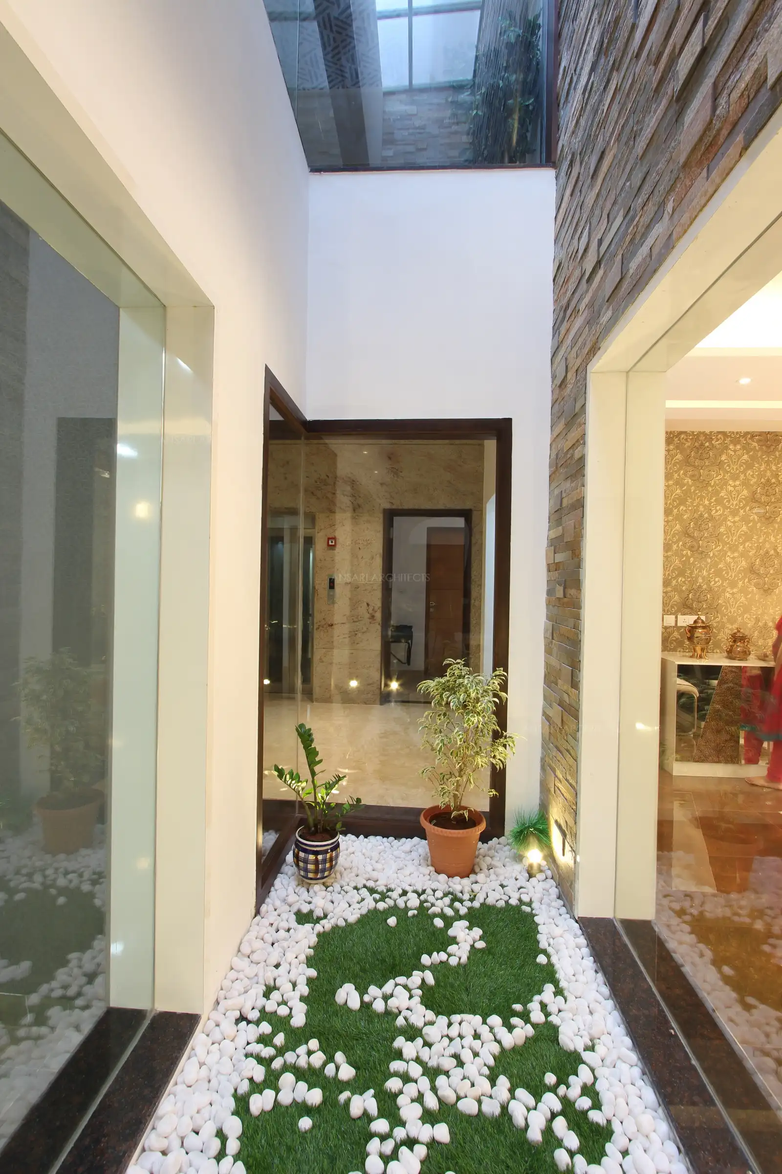The glass doors surround the courtyard to pass on sunlight, with double height space, play of different textures creates a serene space.