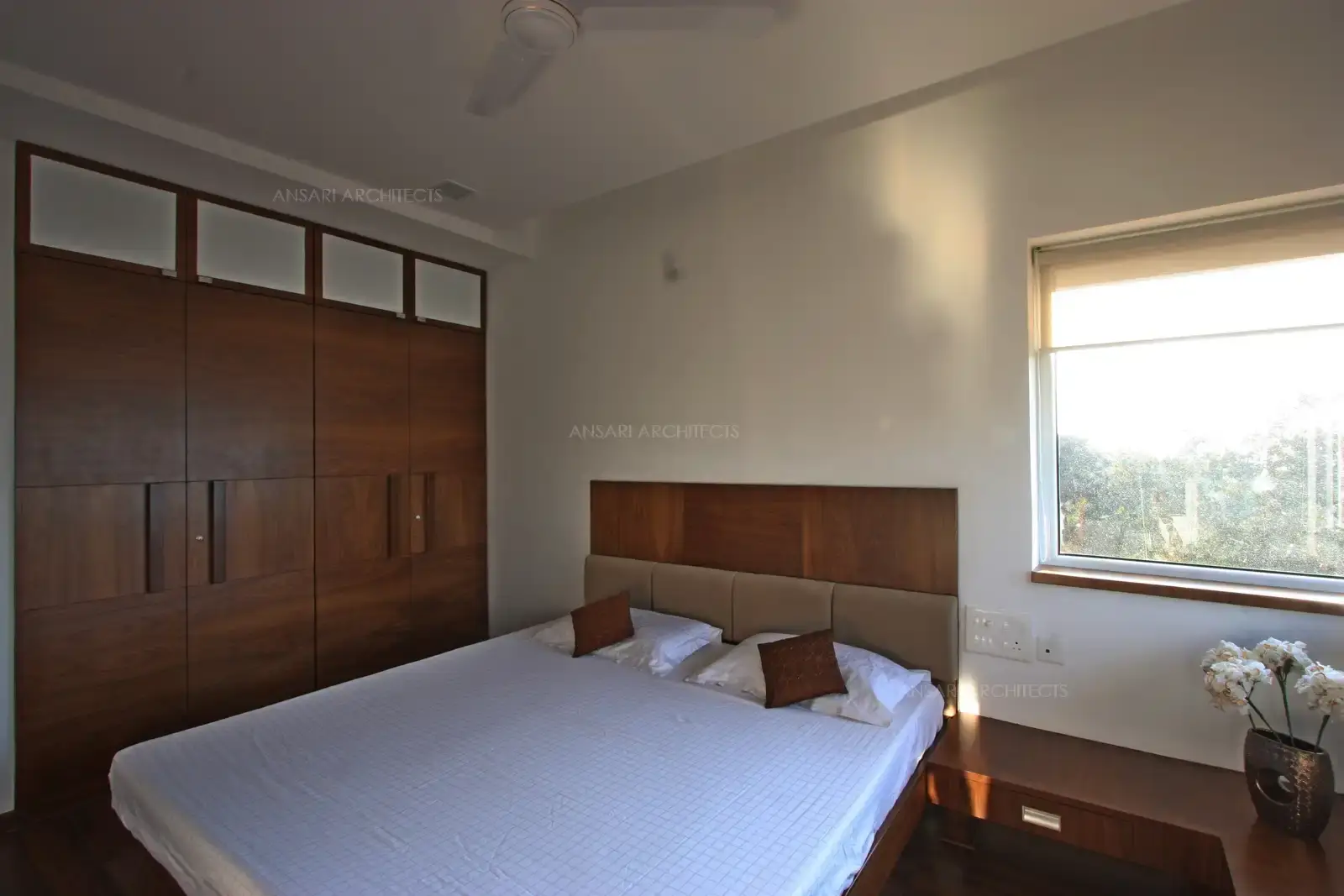Built-in wardrobe with sleek handle-less design and glass panels, providing maximum storage and a streamlined look.