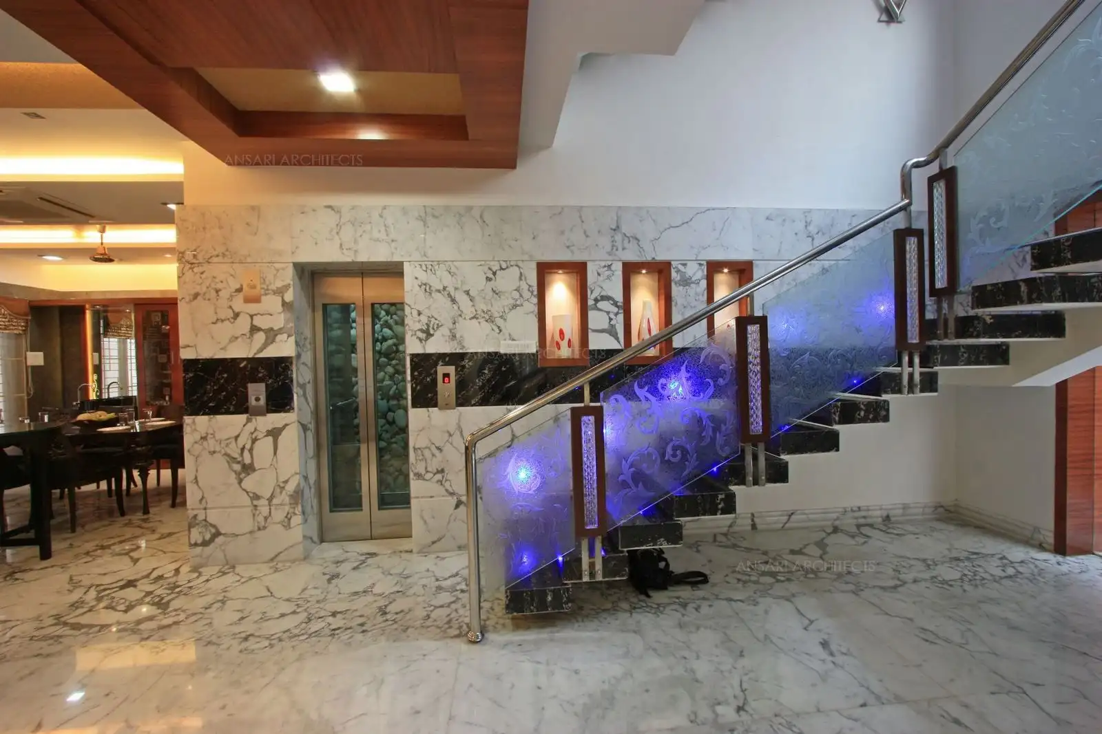 Niches have been given in the wall with wooden frames and wooden false ceiling to highlight the staircase area.