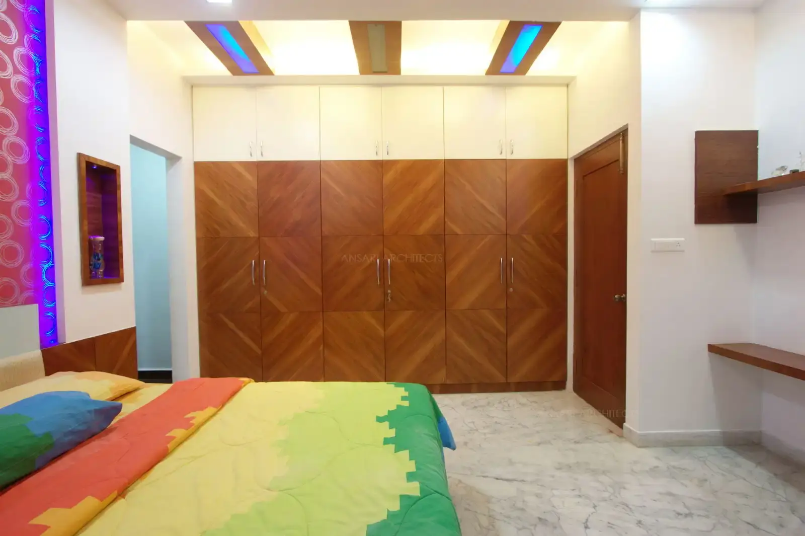 Wardrobe has been designed with lofts for better storage which is concealed in white painted glass to avoid the space from looking too heavy.