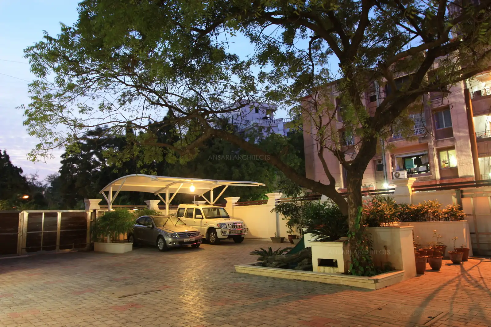 The car parking near the front entrance main gate has been covered with light Tensile roof to avoid blocking the view of the house from the outside and protects the cars from excessive heat during the daytime.