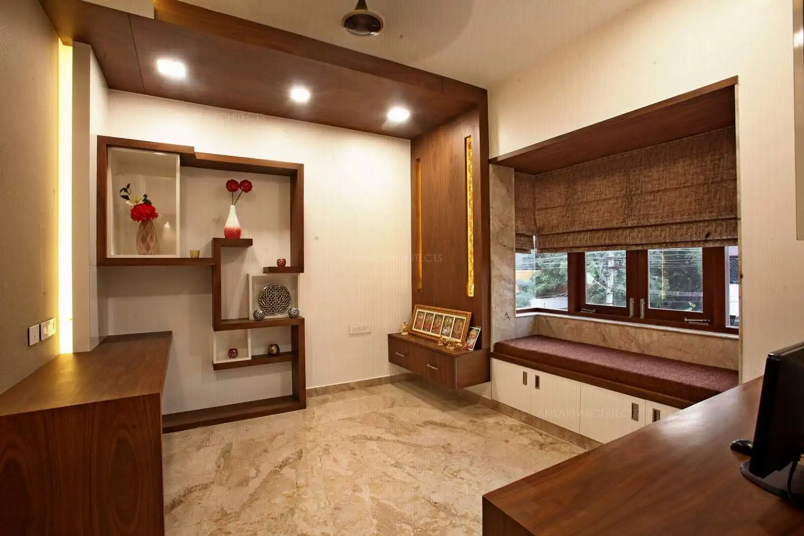 The display unit in wood is with random assymetrical pattern following no order, and looks interesting for display. This unit design highlights the artwork mounted in a good way. The lights here add a large dose of vibrancy combined with the simple pooja unit with backlit wooden cladding.