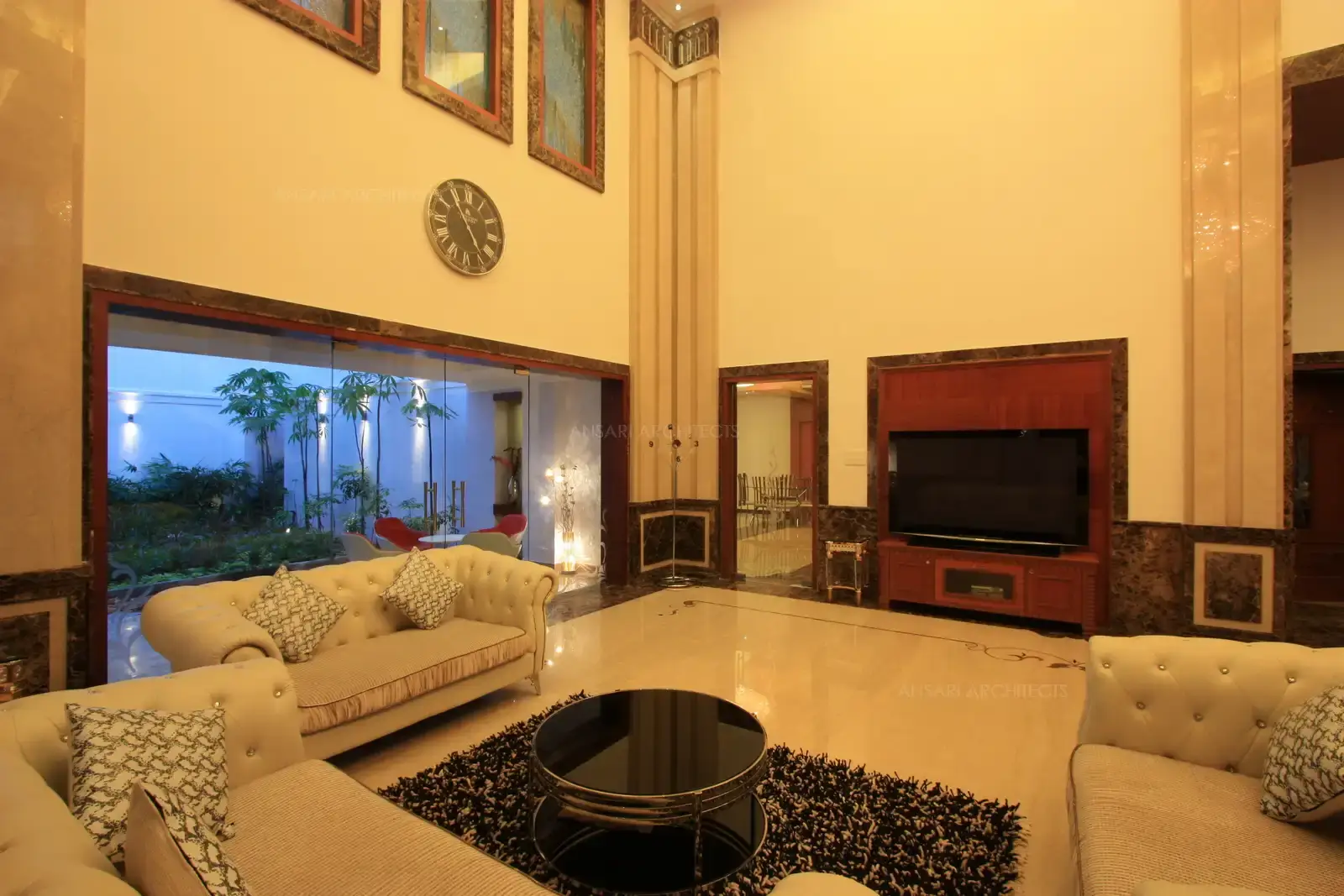 Vertical posts in marble finish used along the height of the wall give a sense of royalty in this posh and luxurious house.