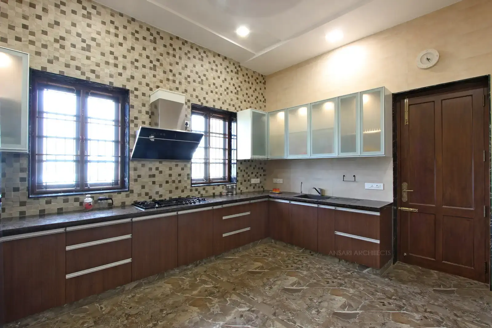 The modular unit kitchen area with the finishes of modern kitchen design. With glass shutters for the storage which includes functionality .