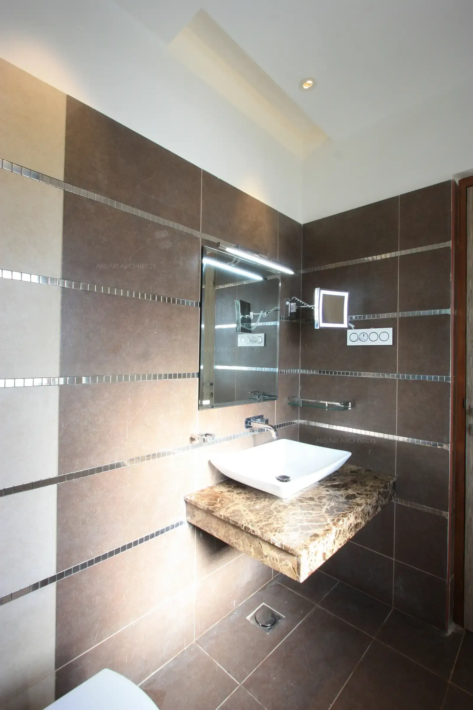 Stainless steel highlighters are used to add a rich look to the master bathroom.17