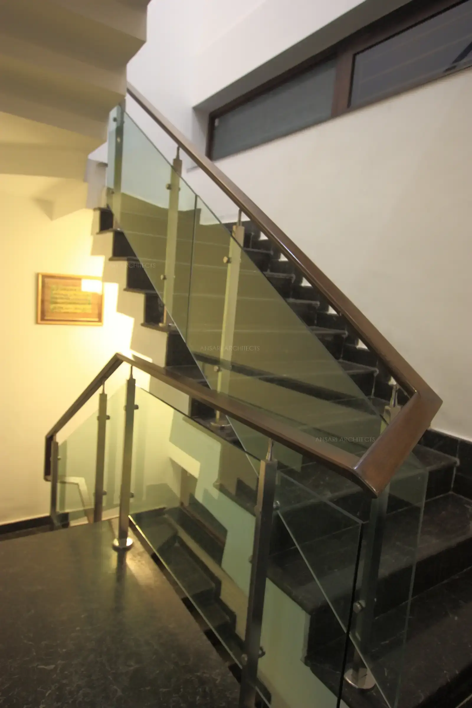 Staircase with wooden and glass handrail leading to first floor..17