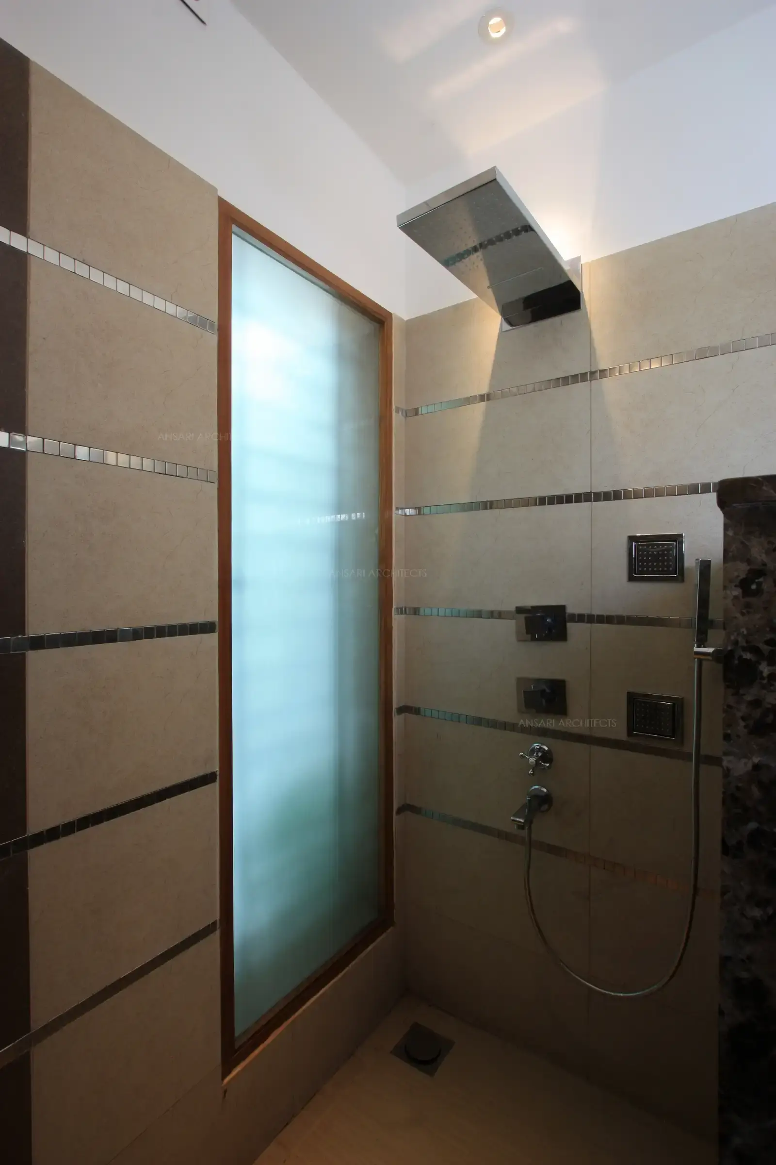A large frosted glass in the shower area add up to the lighting in the master bathroom.18
