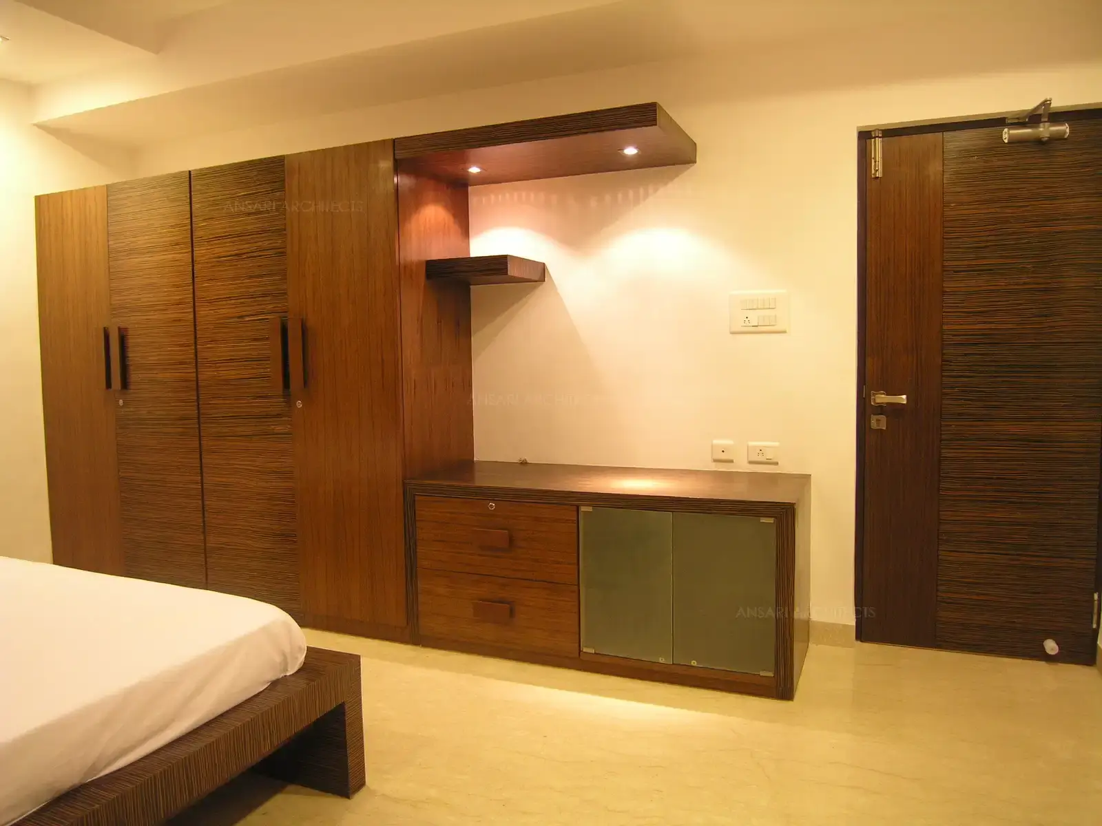 Wardrobe in bedroom-1 is finished in natural veneer with customized wooden handle for all the doors.18