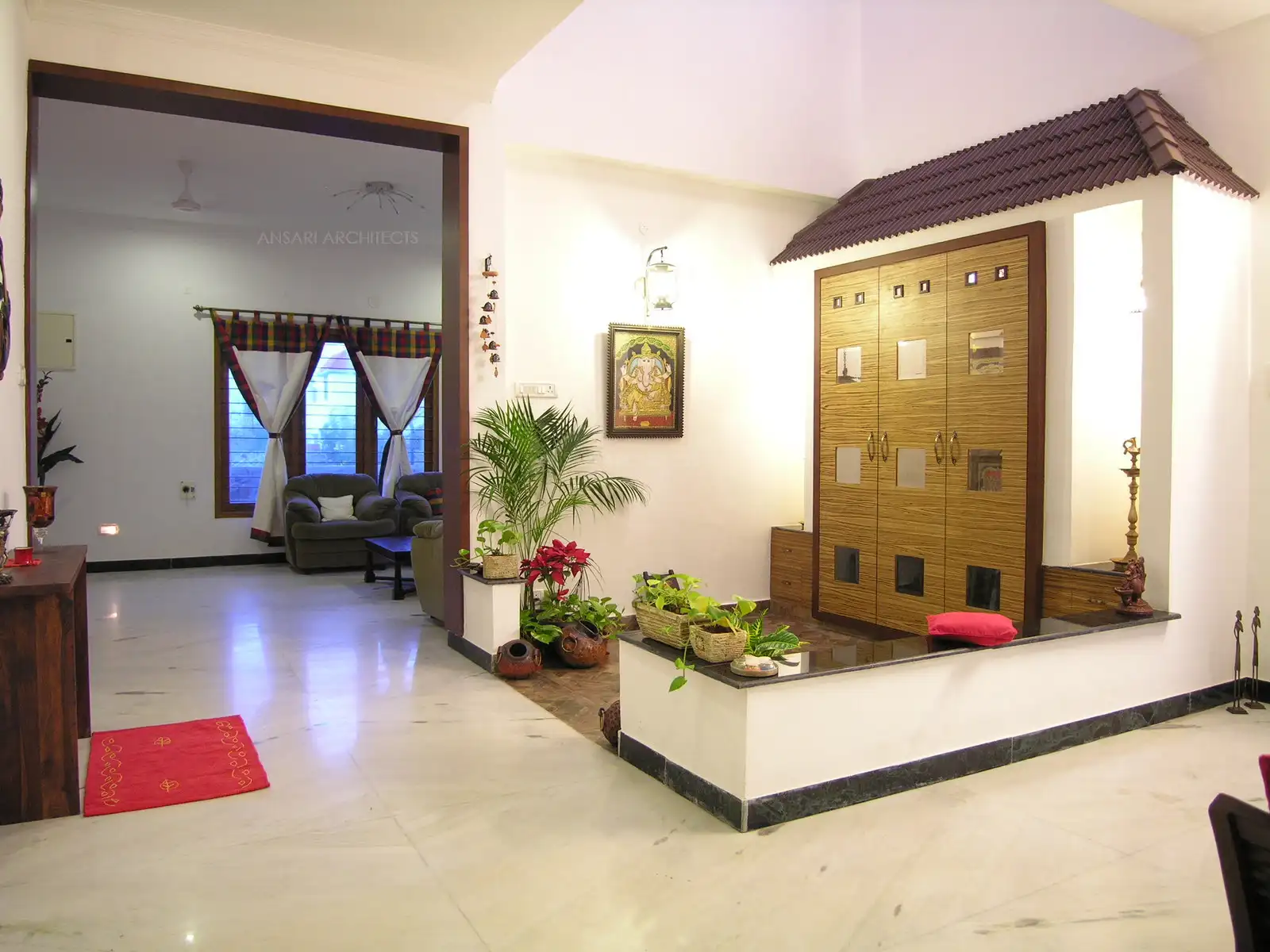 Slope roof and low height wall designed in the puja room gives a traditional look in this courtyard.