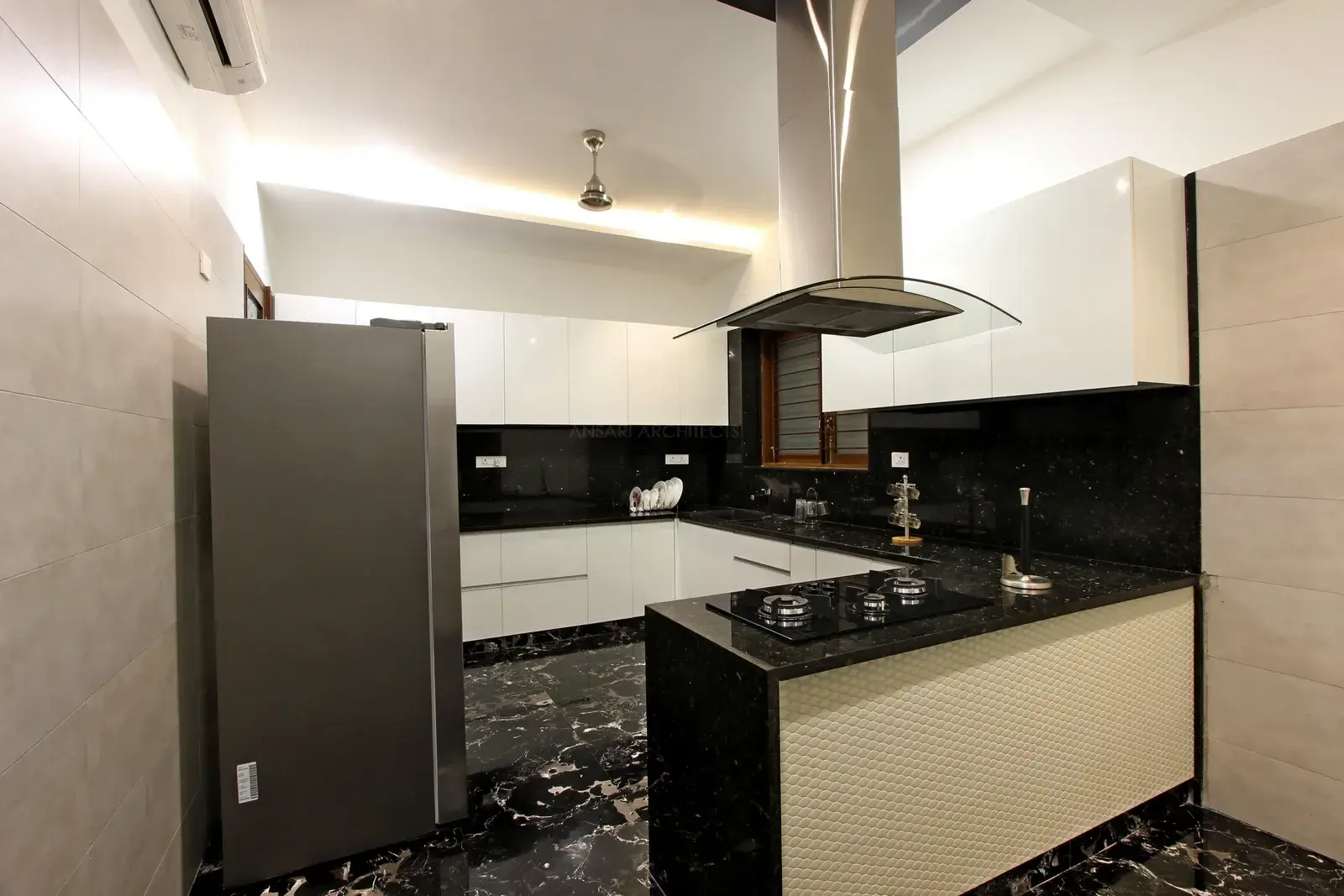 Modular kitchen imparts a sleek, high-end, luxurious look. Kitchen blends well with the overall decor theme. The granite topped counter preserves the sense of place. Colour scheme looks neutral with more white to make it look spacious.