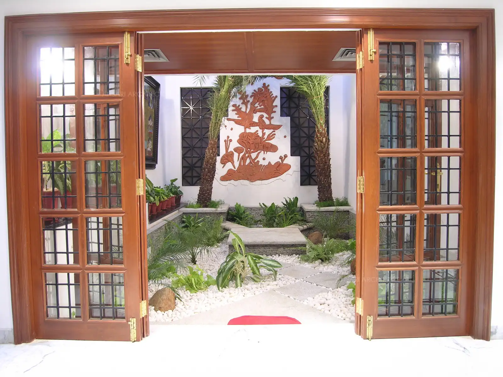 When the teakwood doors of the courtyard are open, it gives the possibility of coming through the courtyard entering into the house.