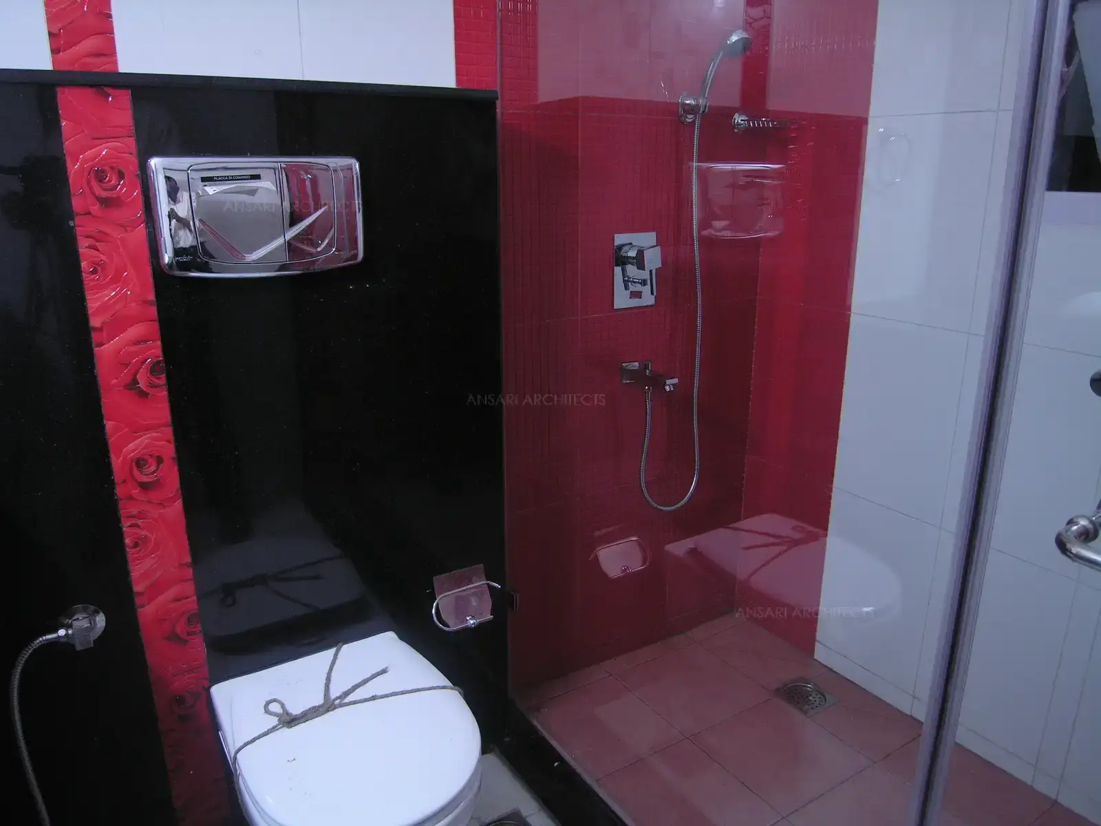 Toilet of bedroom-1 is bright and vibrant with colour scheme of red,black and white.