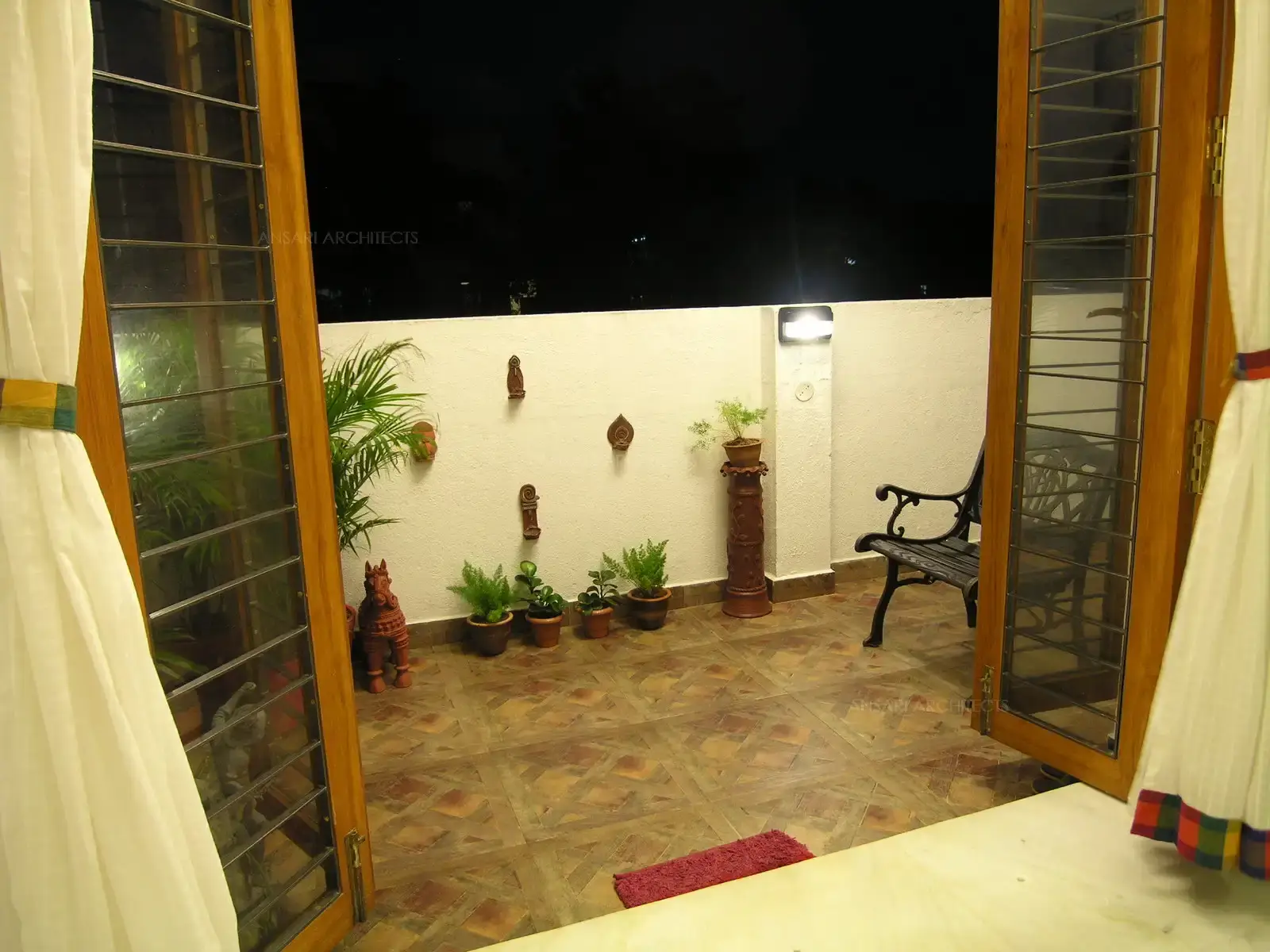 Balcony in the first floor has been designed with seating and simple murals and planters around the wall.