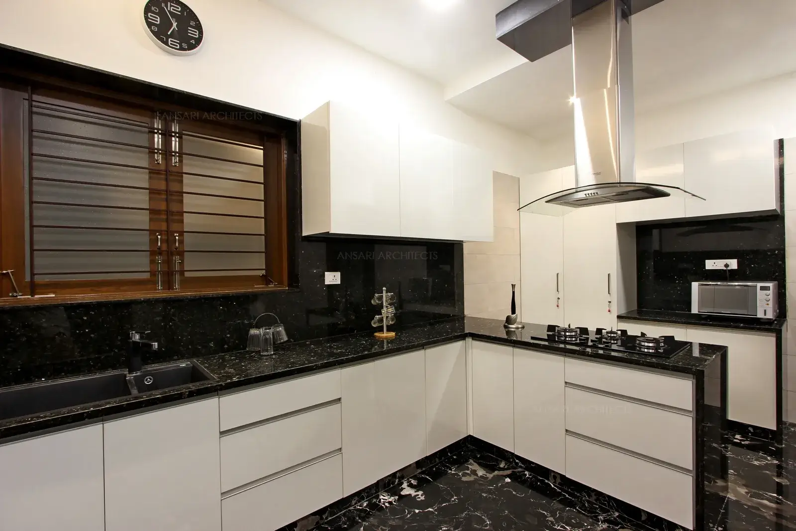 The recessed lights gives the ceiling a clean look and enhances the expansive feel of the space, Sleek and sophiscated style is kept intact by choosing marble of a rich darker shade of the surrounding colour scheme. This gives a serene look.