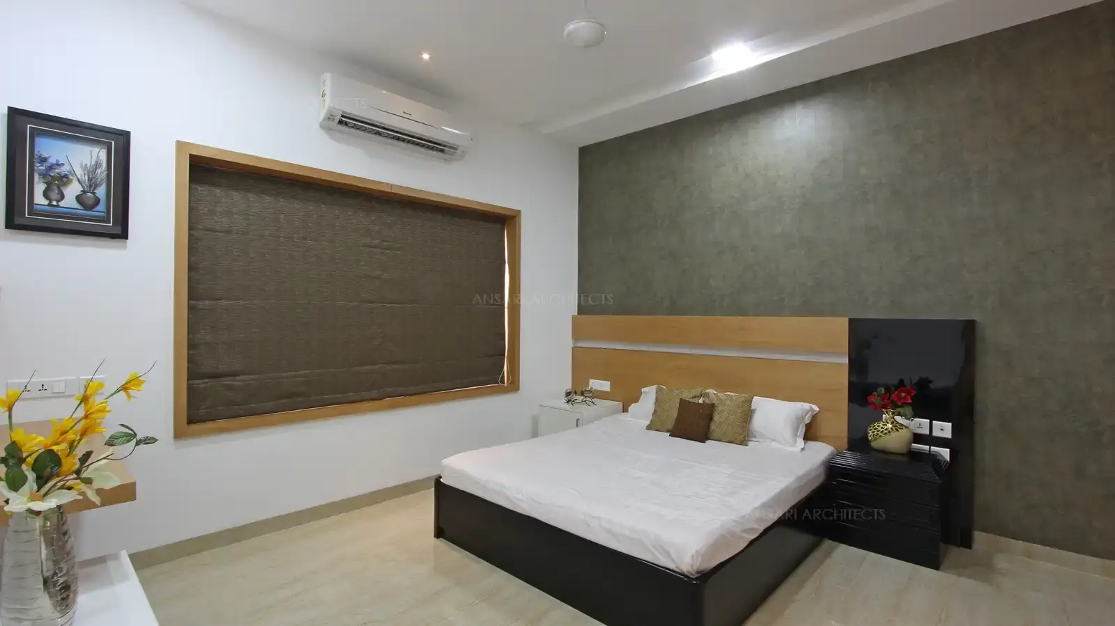 The bedroom is a cosy space filled with contemporary elements,. The warmth of the walnut coloured headboard veneer is contrasted with the richness of the wallpaper backdrop, the sidetable with paneling in glossy finish which adds to limited ornamentation.