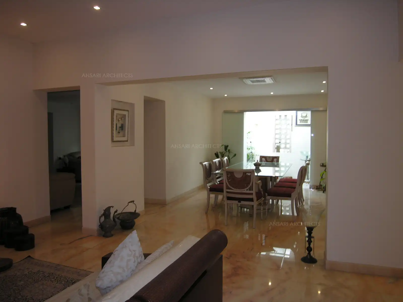 Courtyard in the dining room divided by a clear glass brings in abundant natural light.