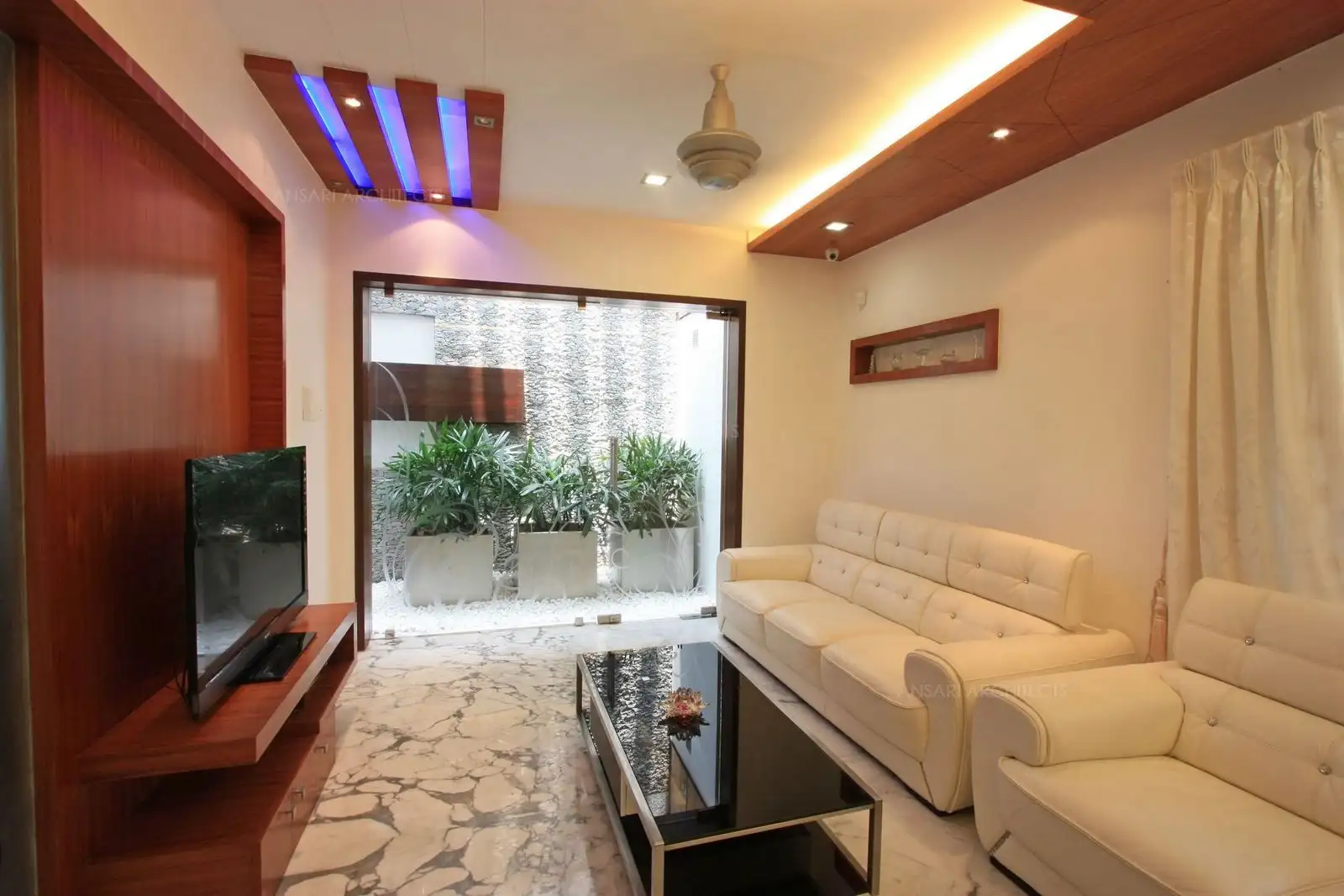 Drawing room in the entrance has access to the courtyard which has been designed with rustic stone finish in combination with wood.