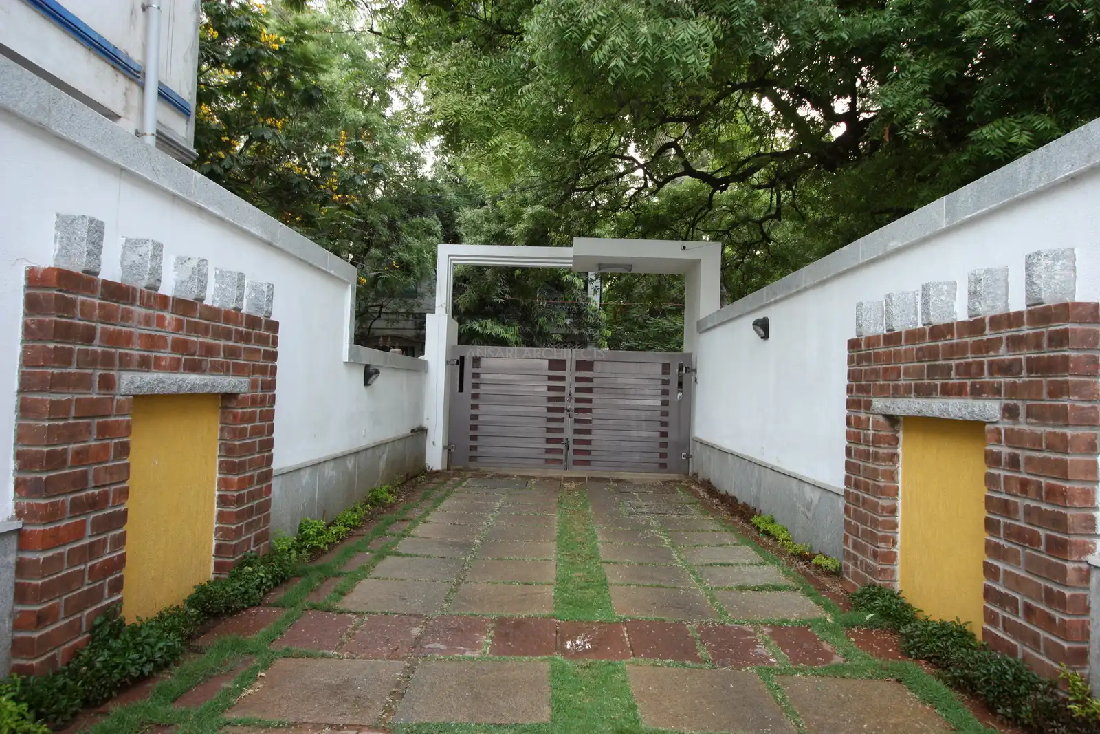Main gate with long passage which leads to the house has been designed with interesting feature on the wall with rustic brick finish, insulates the house from the hectic traffic noise and pollution of the city.