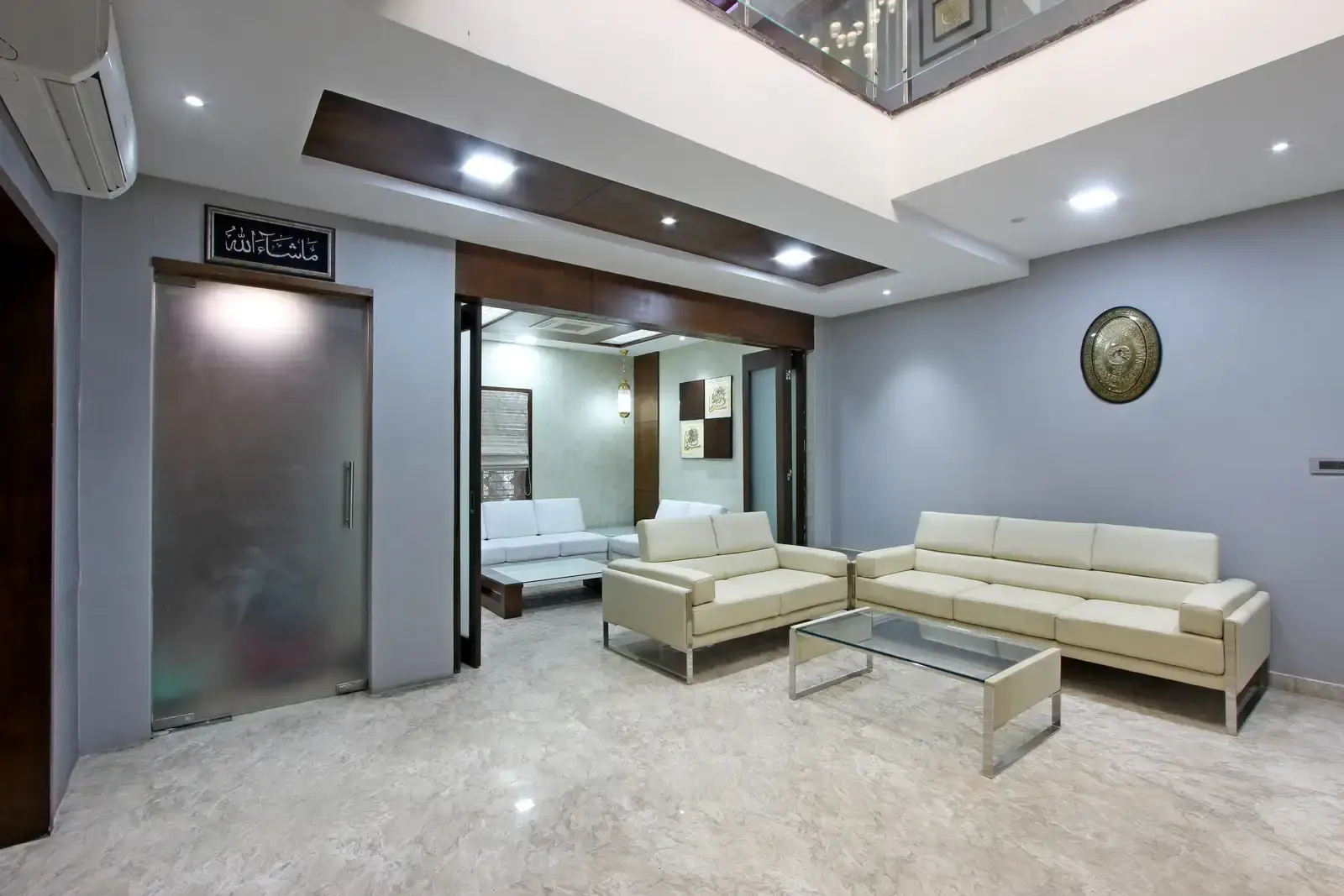 Soothing walls and floor get the golden touch from recessed lighting. More depth is brought into the decor with the help of bits of veneer