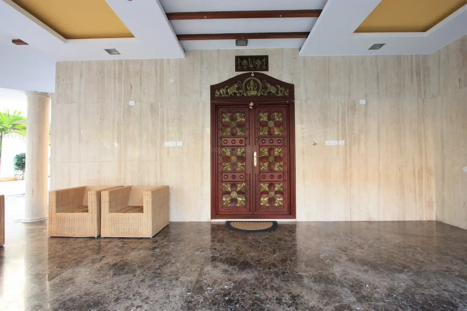 The main door has been decorated with the Heritage brass inlay Works to suit the style of the building. Italian Travertine marble wall cladding on the wall surrounding the main door, and on the circular pillars have been done.