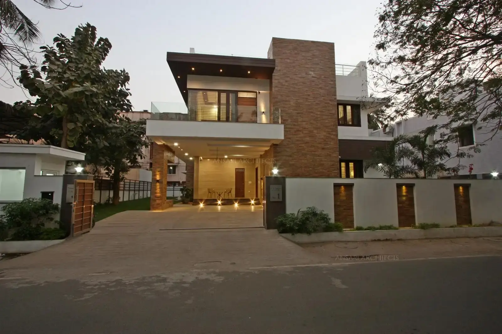 The facade features a main stone featured textured dominating element which highlights the building. The house maintains a vibrant, organic connect with its natural surroundings through the landscapes in the exterior. The compound wall designed specifically with rectangular punctures highlighted by stone textures.