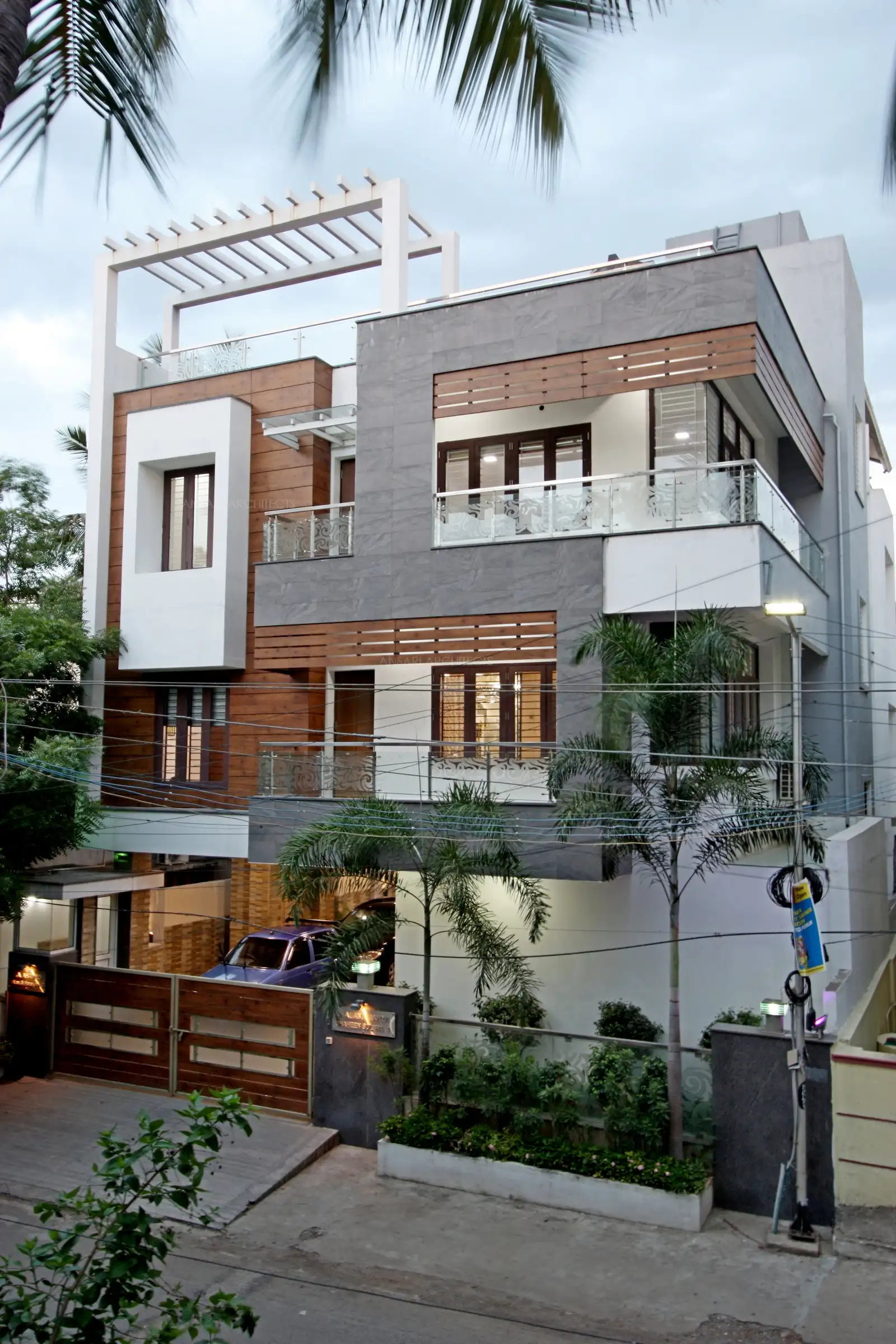 - Exterior view of the house has been designed in simple white with stone and wooden cladding which gives a stupendous contemporary look.