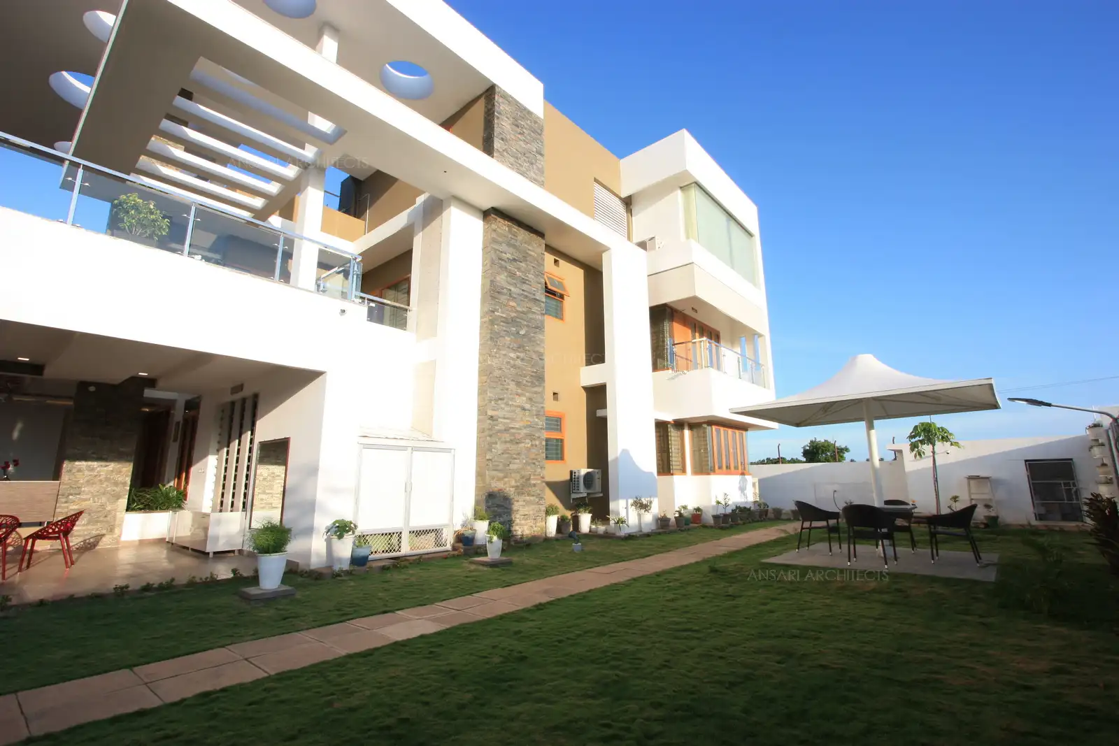 Exterior view of west facing building with huge garden area in the front. Lawn in the front helps to maintain cool & comfortable temperature inside the house.