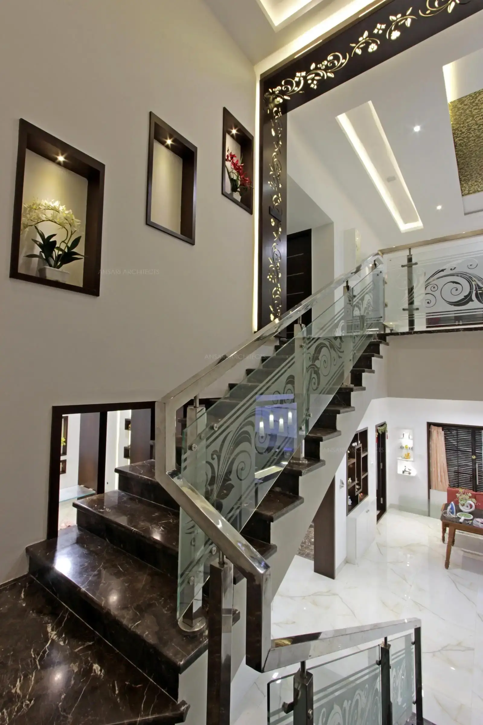 The staircase colour is reiterated all over the panelling, glass handrails bring in a sense of visual lightness, niches arranged in sequence with selected artifacts bring in a sense of uniqueness to the design.