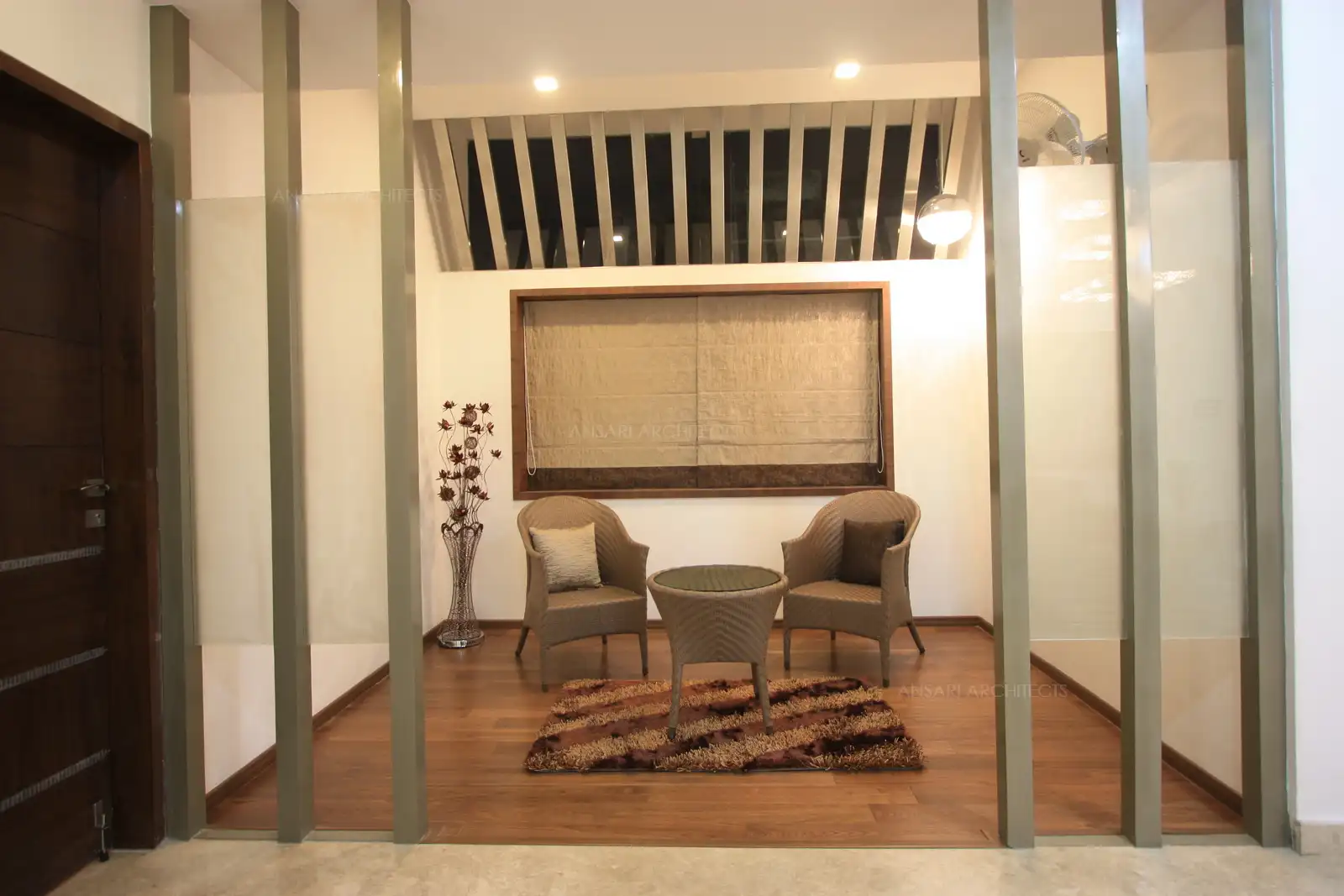 The sit out area in the family room has been distinctively divided with rich wooden flooring and sleek partition.