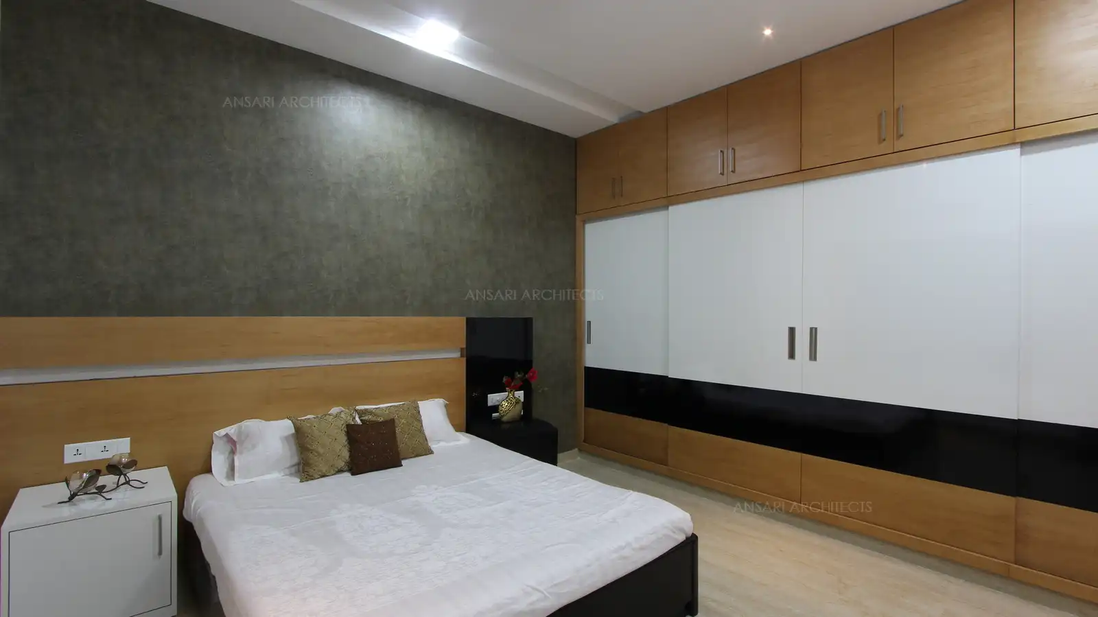 The theme continues towards the wardrobe with same style and colour with the neutral hues, false ceiling looks simplistic yet sophiscated for the space.