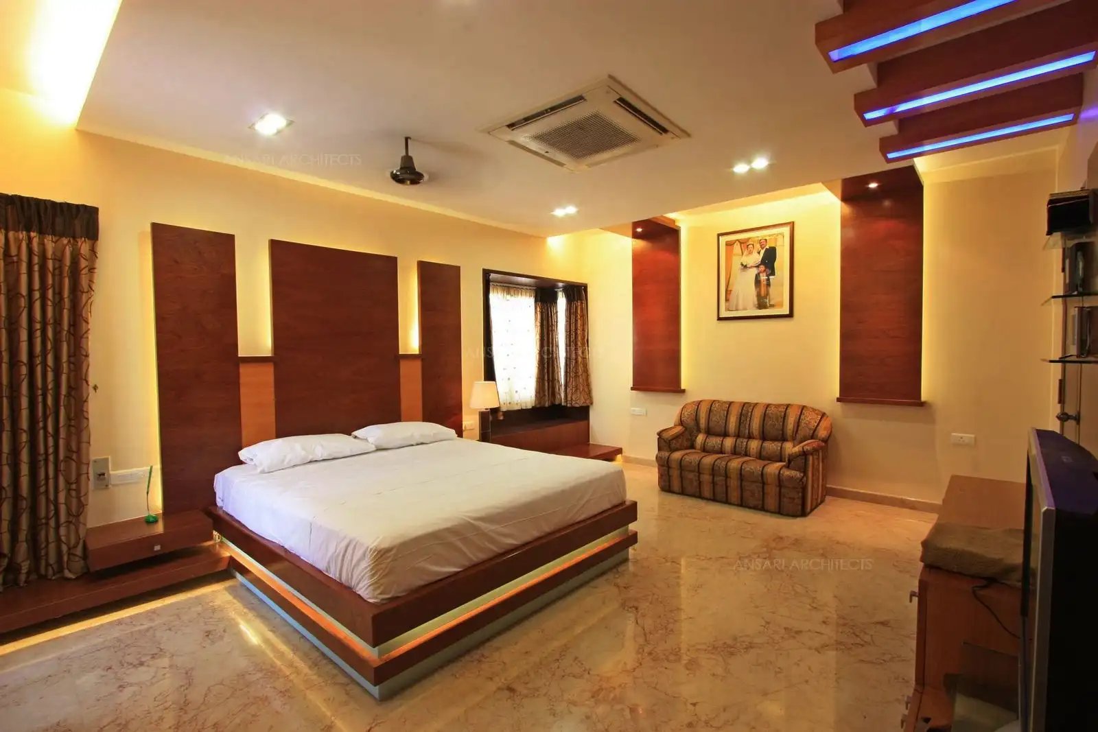 View of bedroom-1 showing the wood panelling behind the bed with concealed lights.