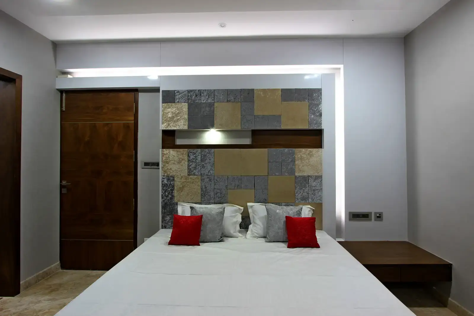 The headboard with vibrant hues patterned grid with veneer punched in between with sleek wooden side table.