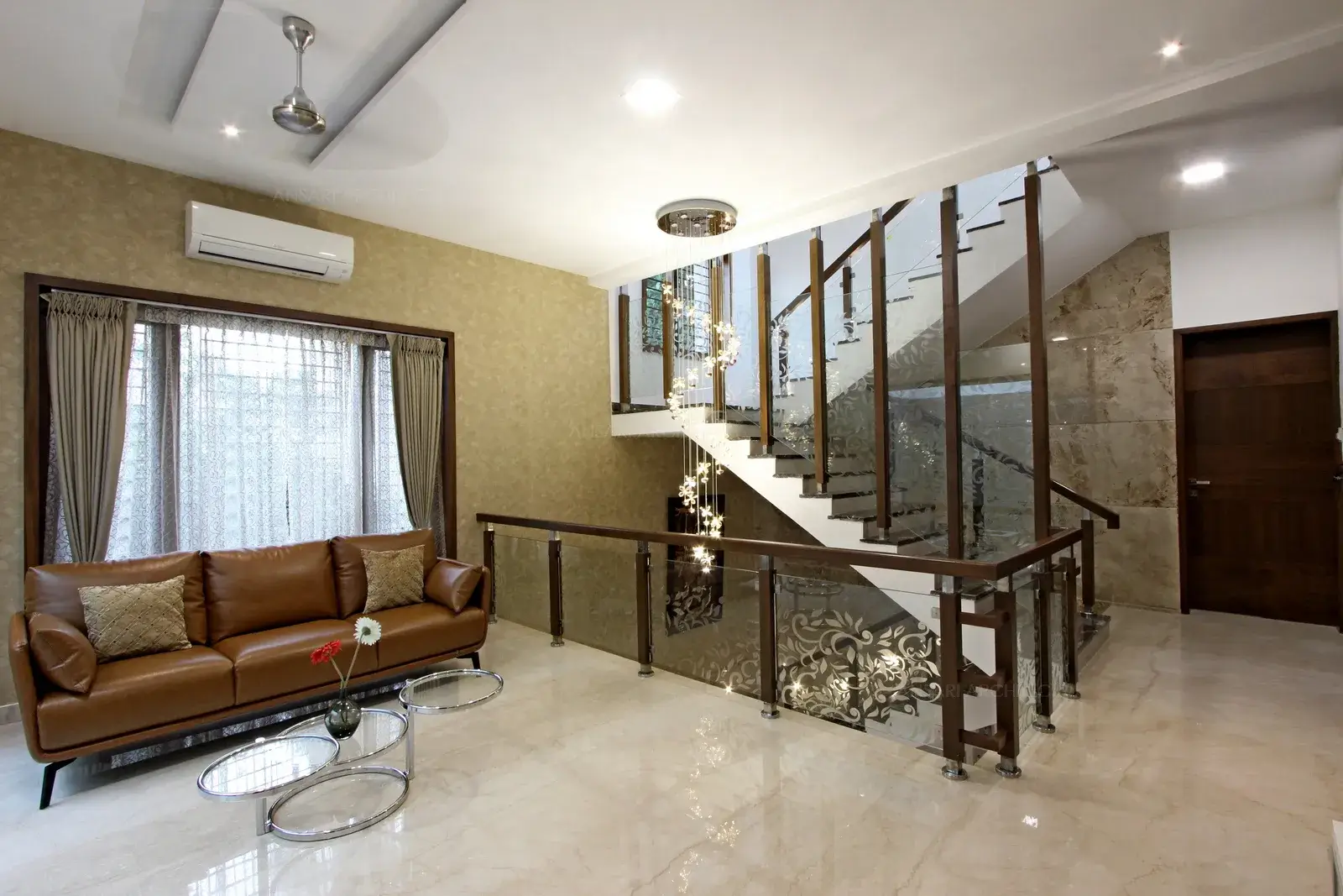 The staircase space is lit by decorative glass sputnik luminaire overhead notches the glam quotient, glas handrails with majestic wooden battens provides in a classic vibe.
