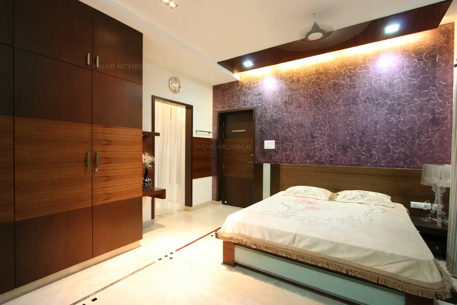 Bedroom-2 in the first floor has been designed with two shades of veneer with contrast colour patterened effect created on the bedside wall.