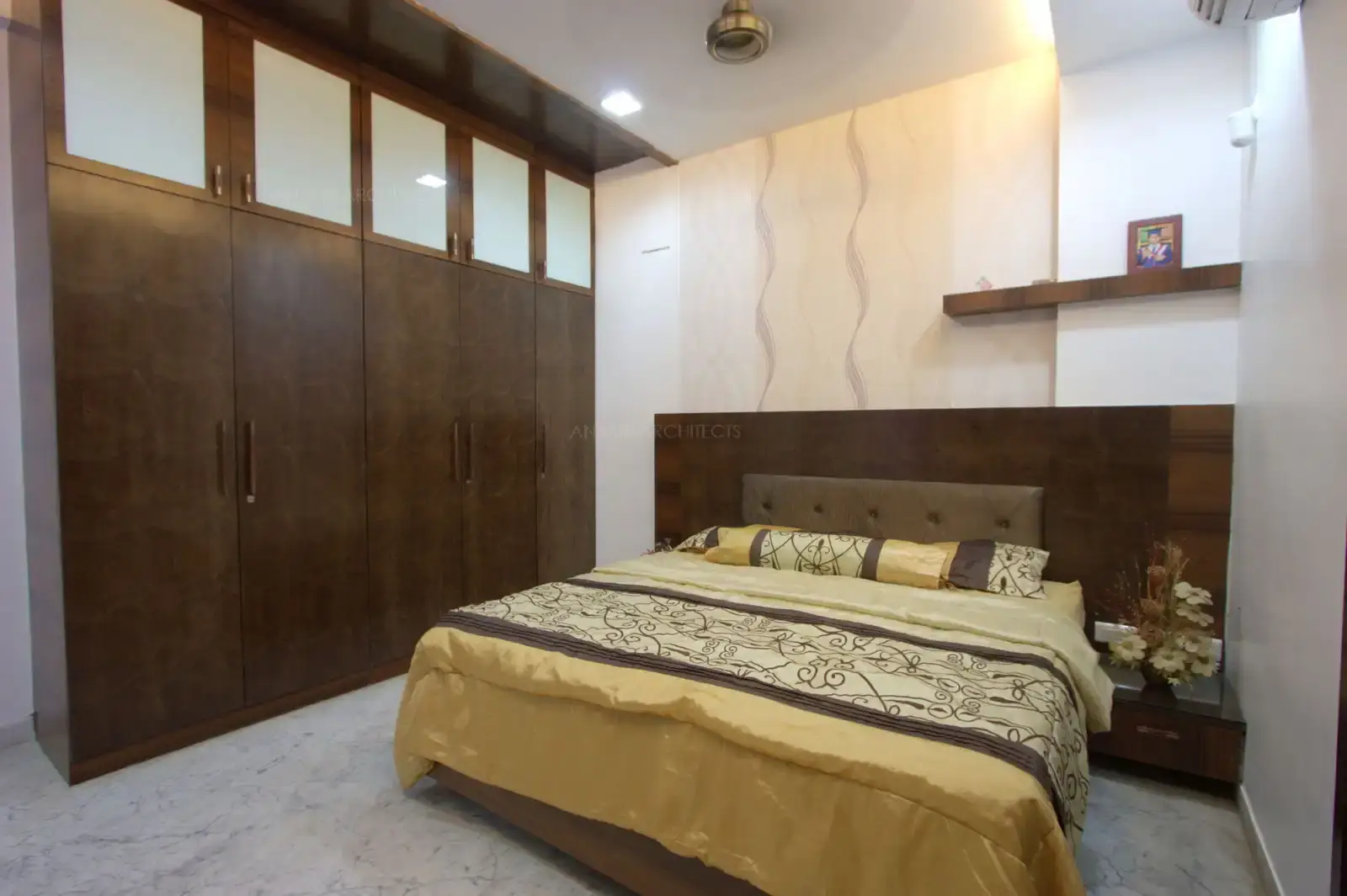 Bedroom-4 looks simple and contemporary with sleek wooden panelling with comfortable back rest behind the bed.