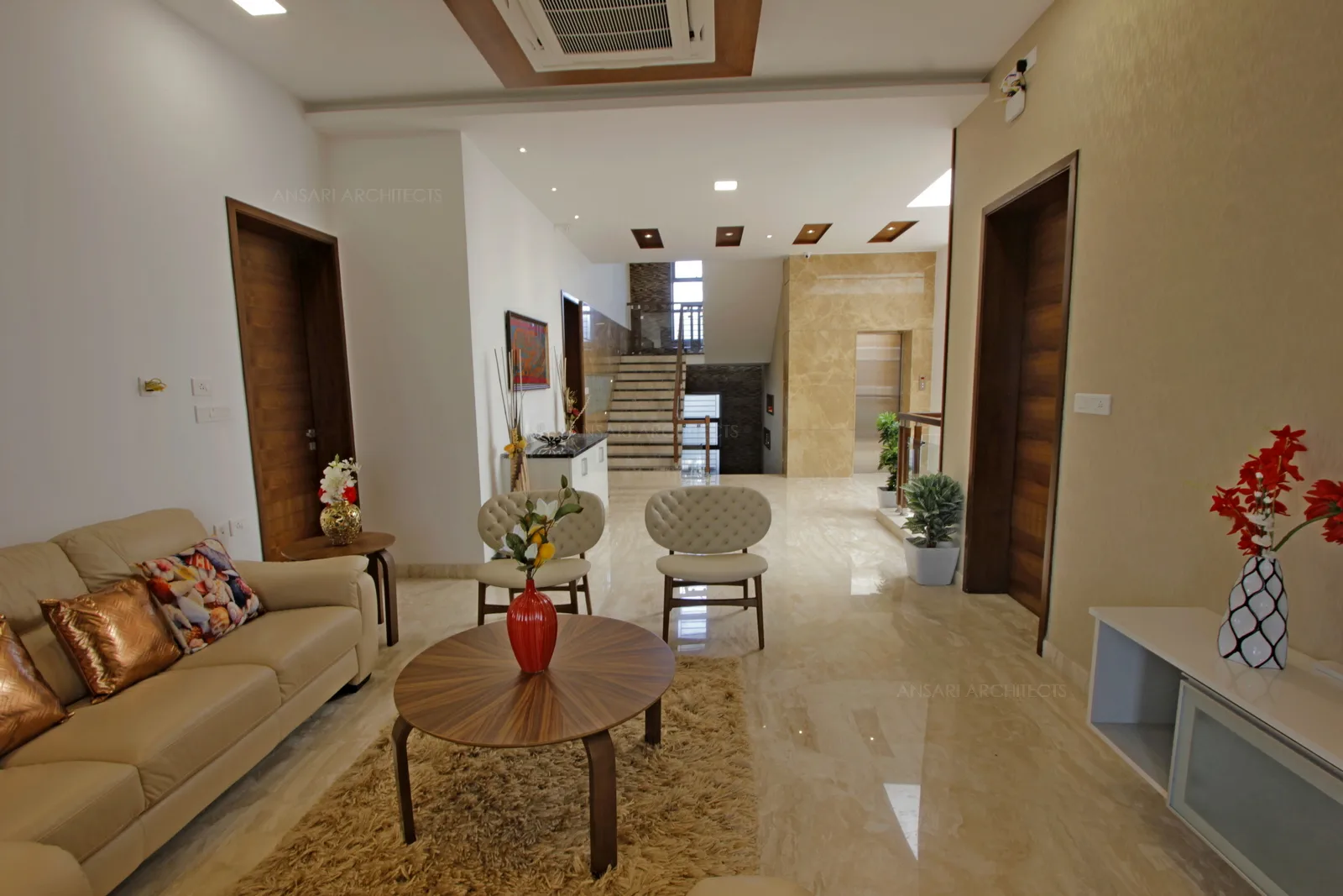 The lounge space overlooks the staircase ceiling is decorated with wood panelled recessed with spotlight, the rectangular array looks indulging with space.