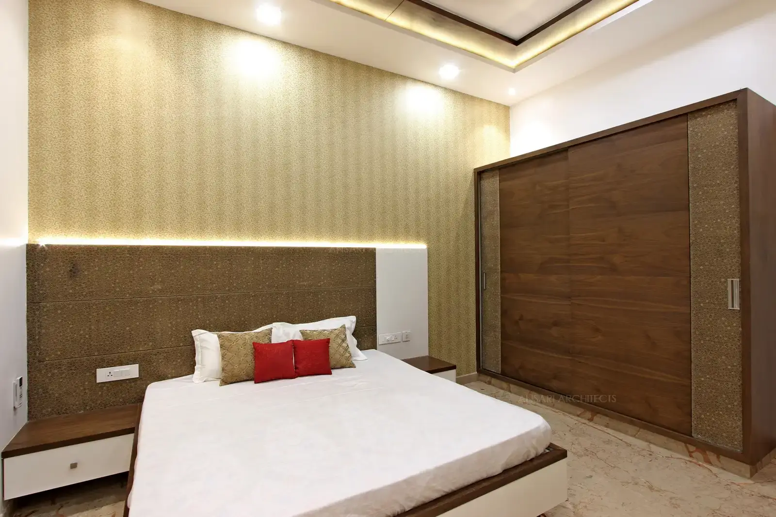 The bedroom is an evolving theme with golden-ochre wall finish adding a subdued dose of colour to the space. A simple headboard with a deep wood wardrobe finish.