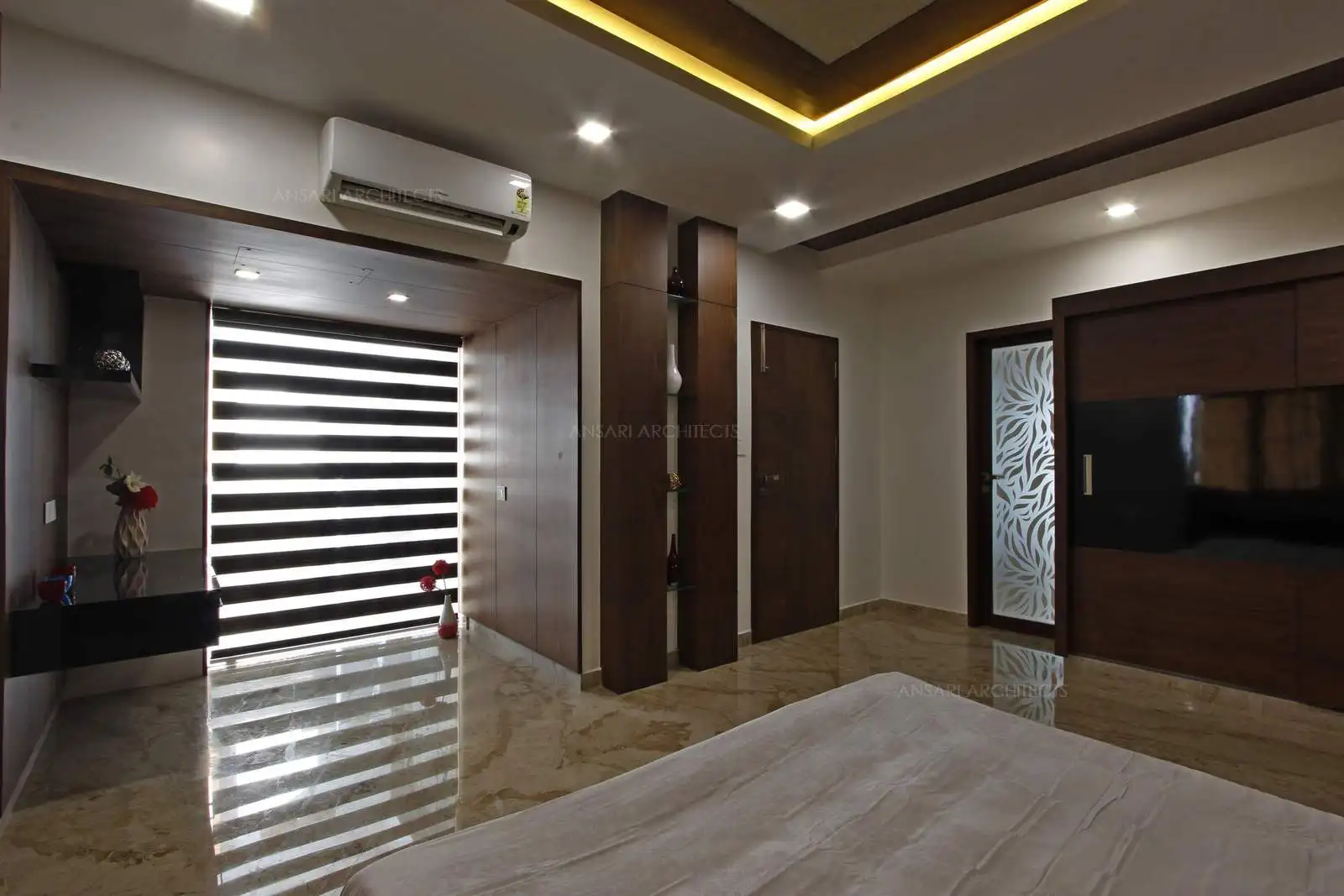 The dark toned storage helps zone out the storage areas, abundance of wall panelling and a light-filled space looks relaxing. The wardrobe adds another layer of warmth with continuing neutral scheme of the bed.