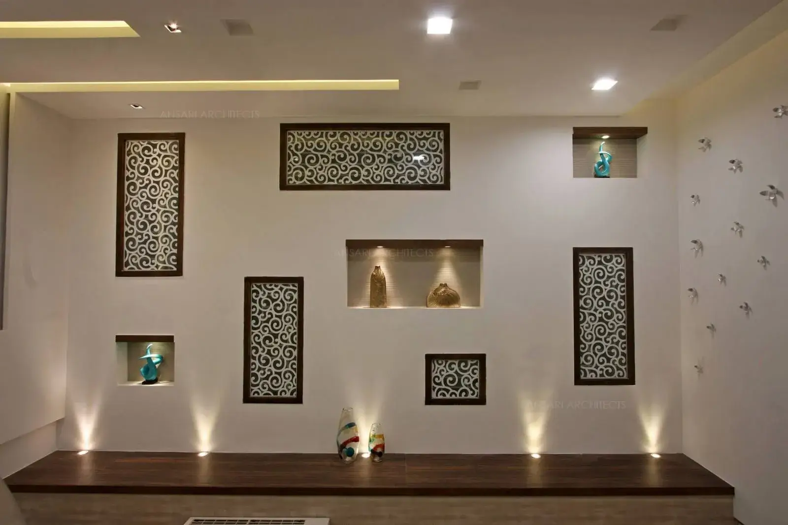 Wall niches provide better functionality for storage and ornamentation. Veneer finishes with spot lights fixed on for elaborating the space.