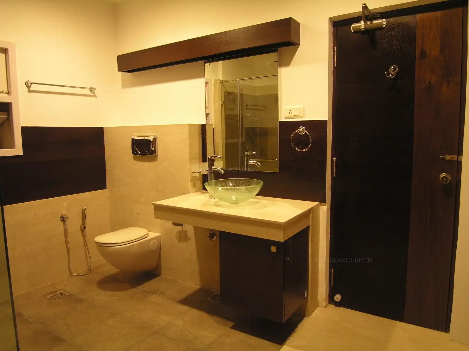 Tiles in the toilet of master bedroom has been matched with shades of veneer used in the wardrobe.