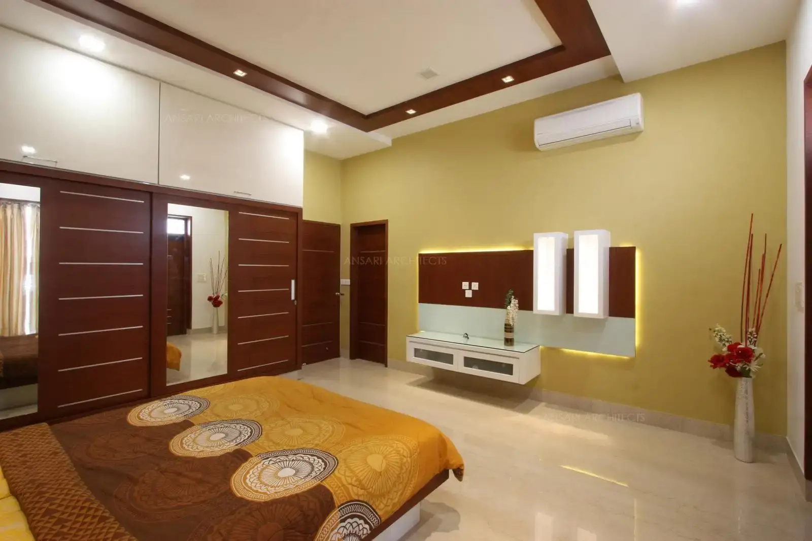 The accent wall is backlit with striking decor. The table along with cabinet is provided and the decor elements are perfectly composed and remains focal point for the room.