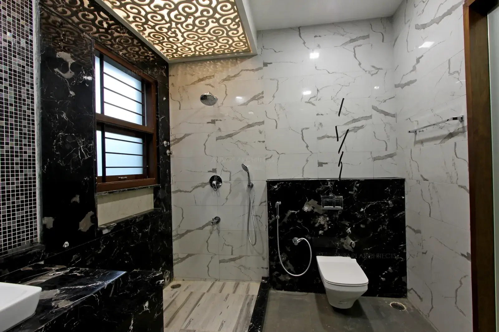 The legde delineates the shower area and the shower niches are inset with tile finish the shower fixtures add a bold stroke to this space.