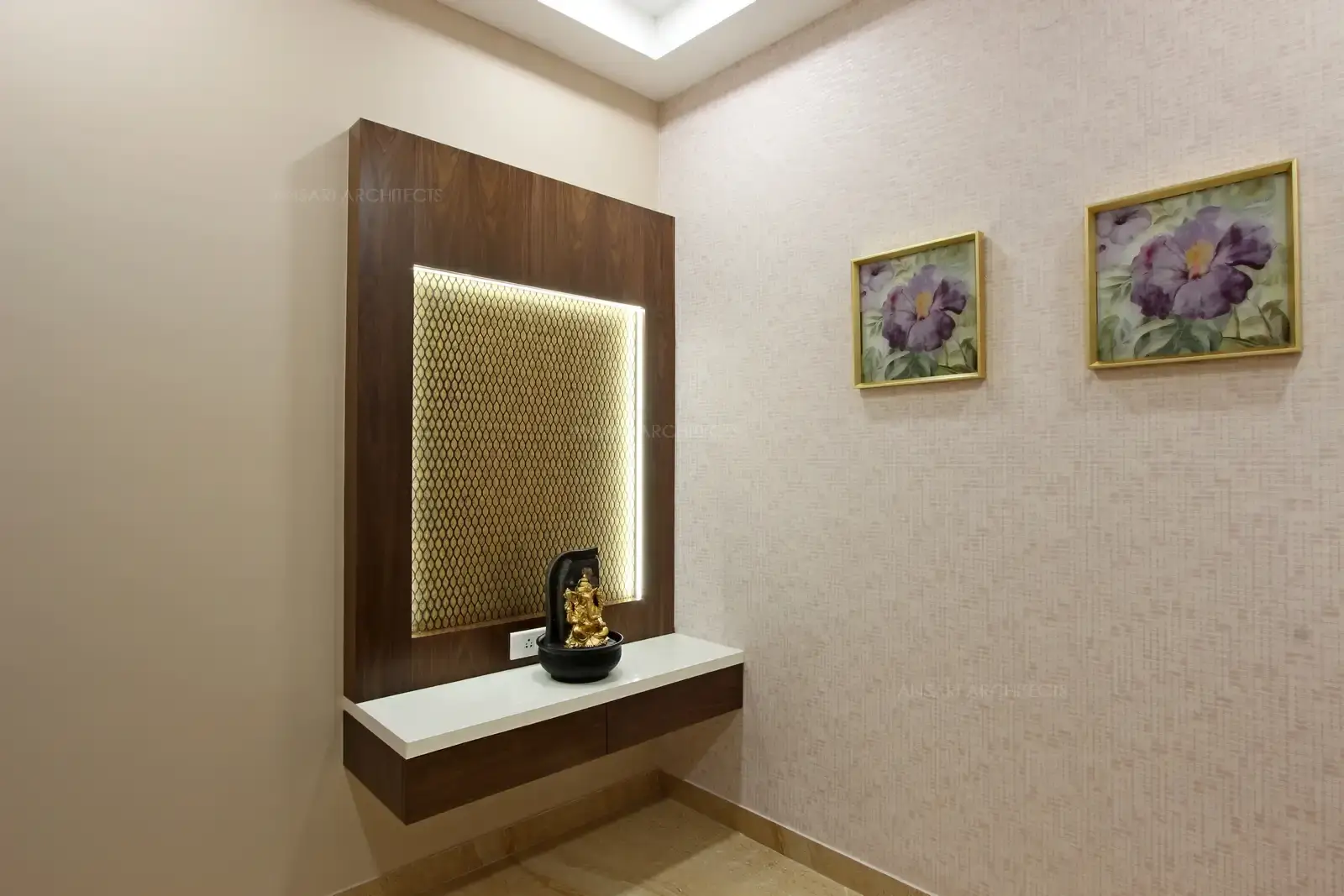 Puja has the decorative wooden panels that infuse colour and texture. Decorative motif in darker wood is positioned in the centre of the wall panelling to become the focal point, with lights to have soft glow over the idol.
