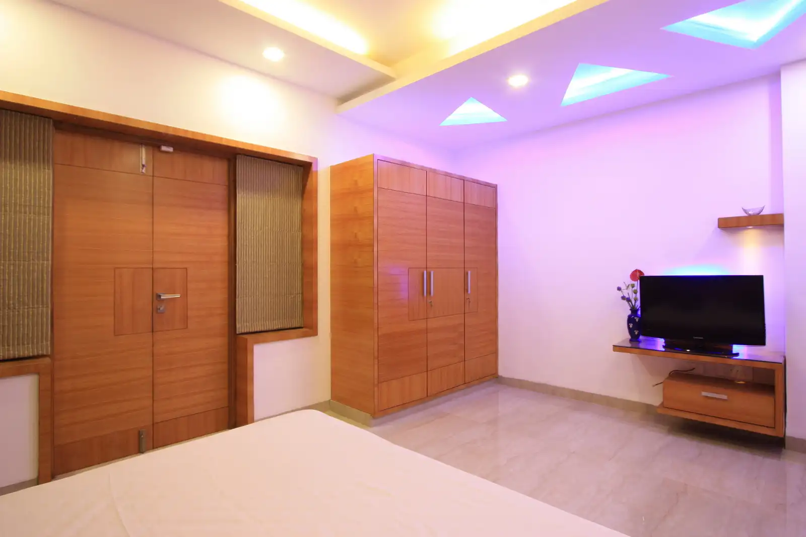Interesting pattern created in the false ceiling with conceal lights dominate this contemporary room.