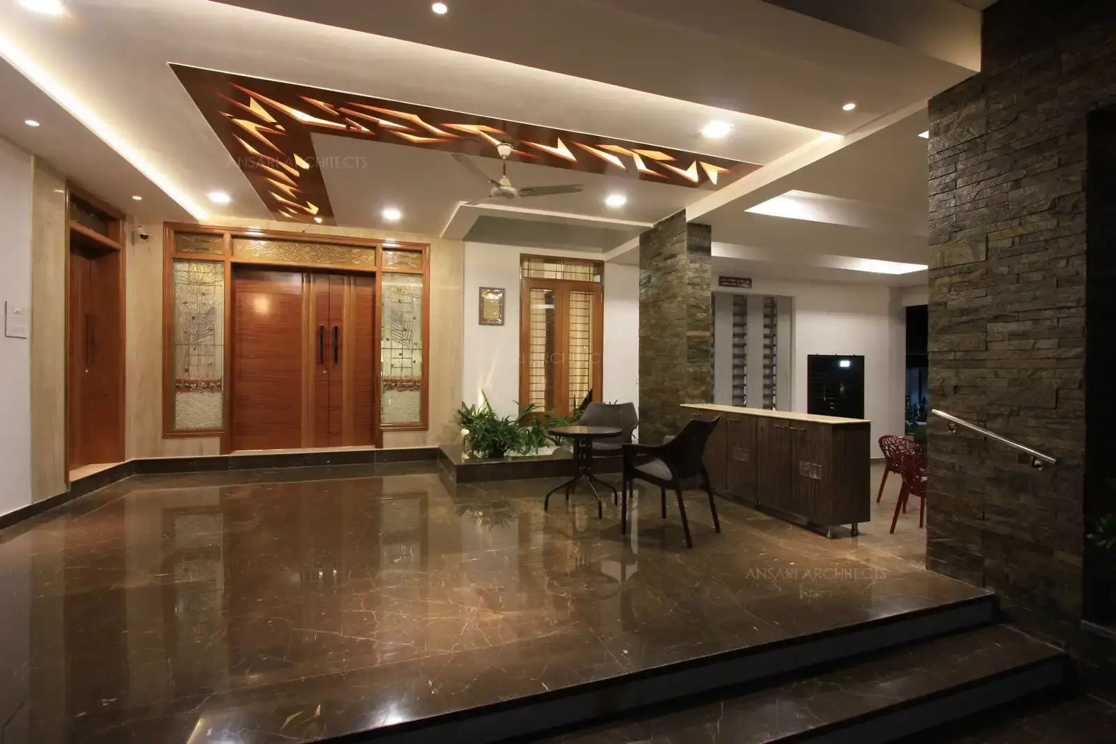 Veranda in the front has a decorative cut out wooden false ceiling in contrast to all white false ceiling area.