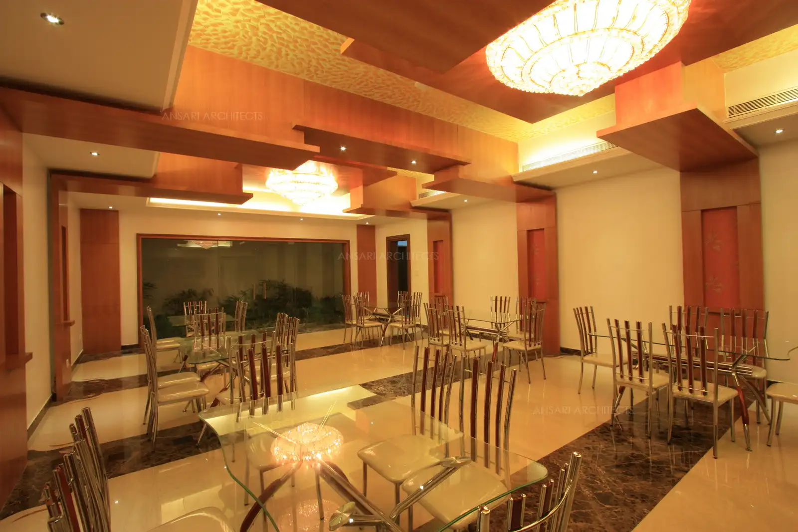 Grand Formal dining area designed for guests are planned for multiple dining tables with wood panelling on the wall for a warm look.
